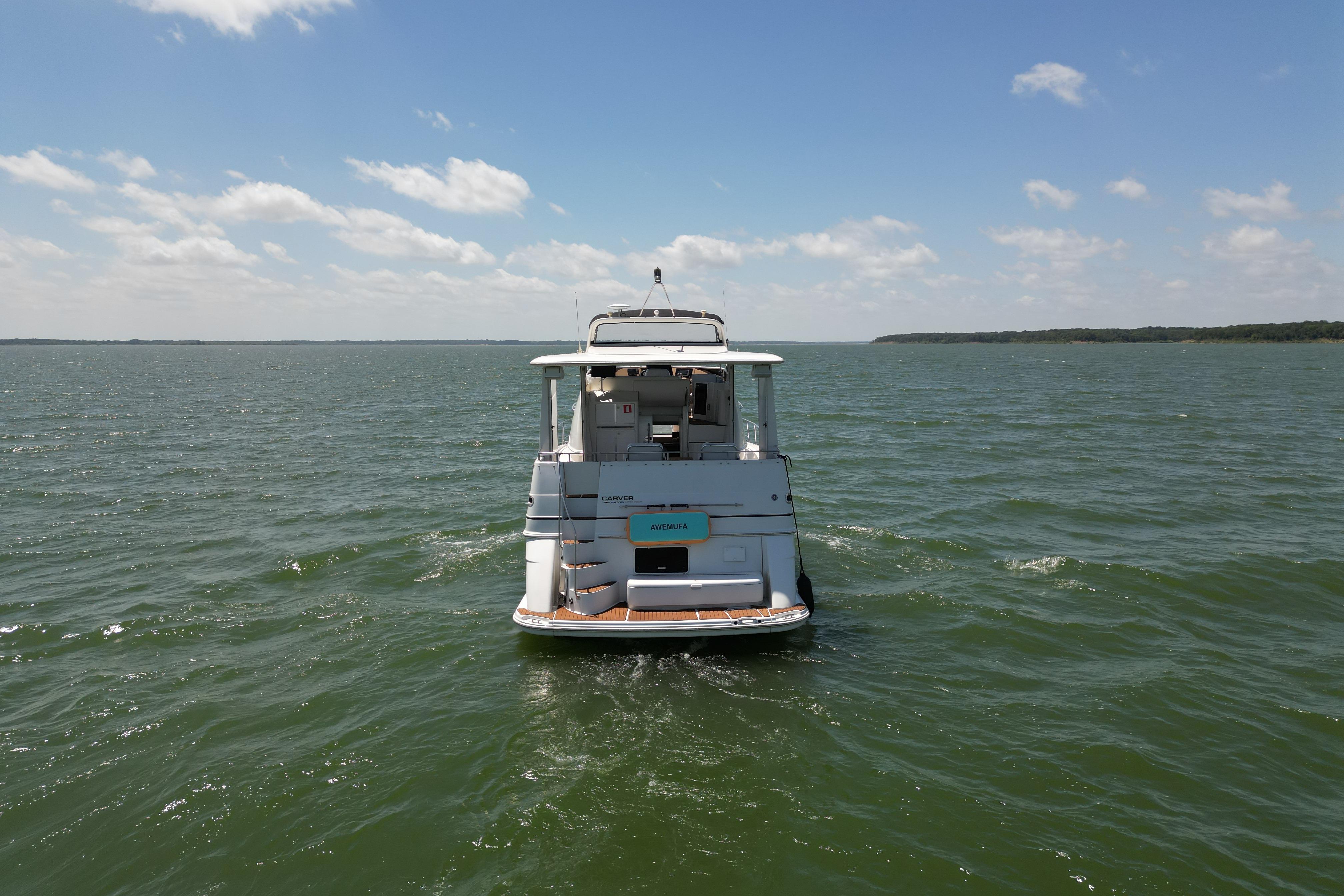 2002 Carver 396 Motor Yacht cruising on open water under a clear sky.