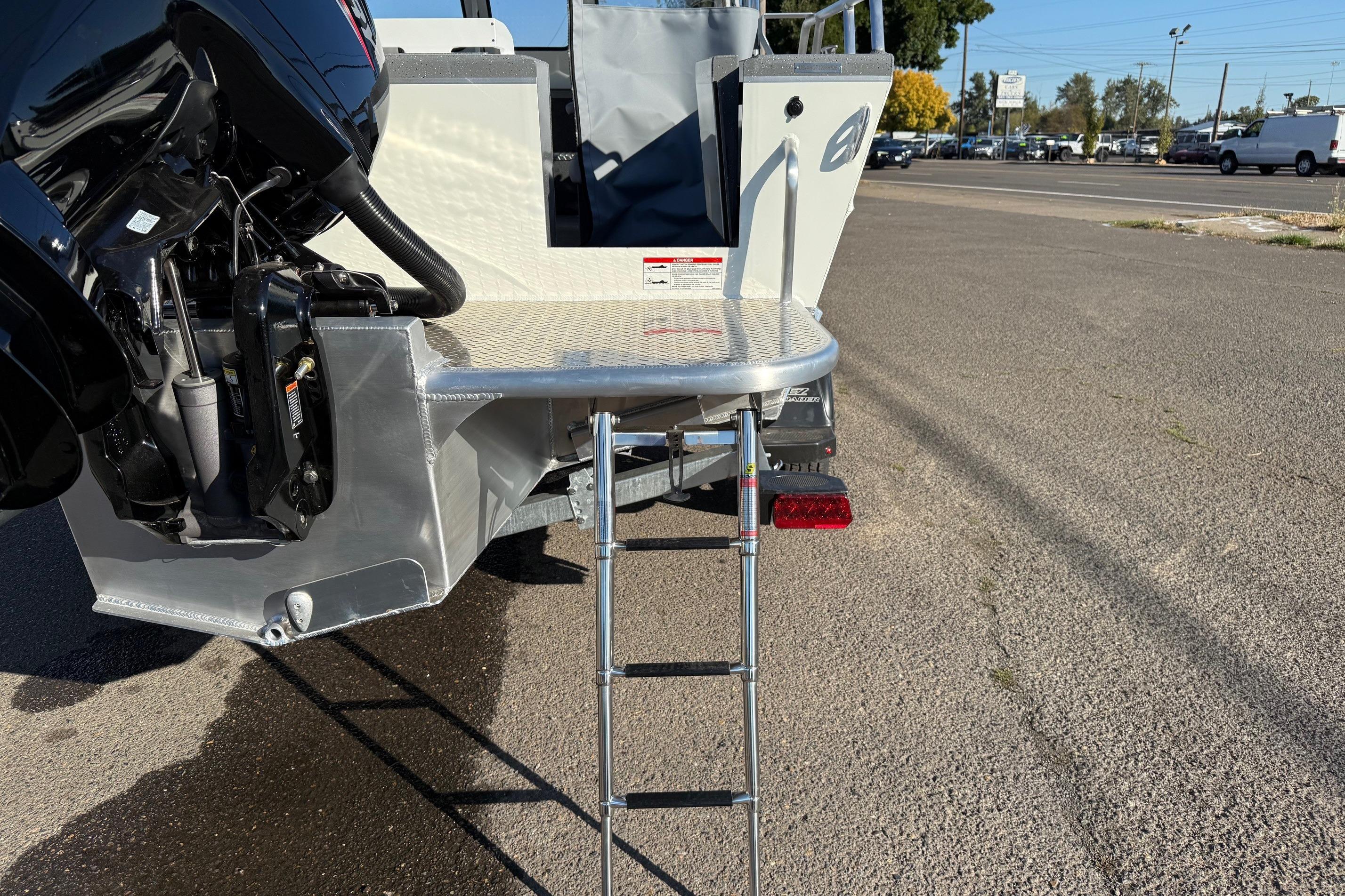 2026 Thunder Jet 185 Luxor boat with ladder and motor, parked on pavement.