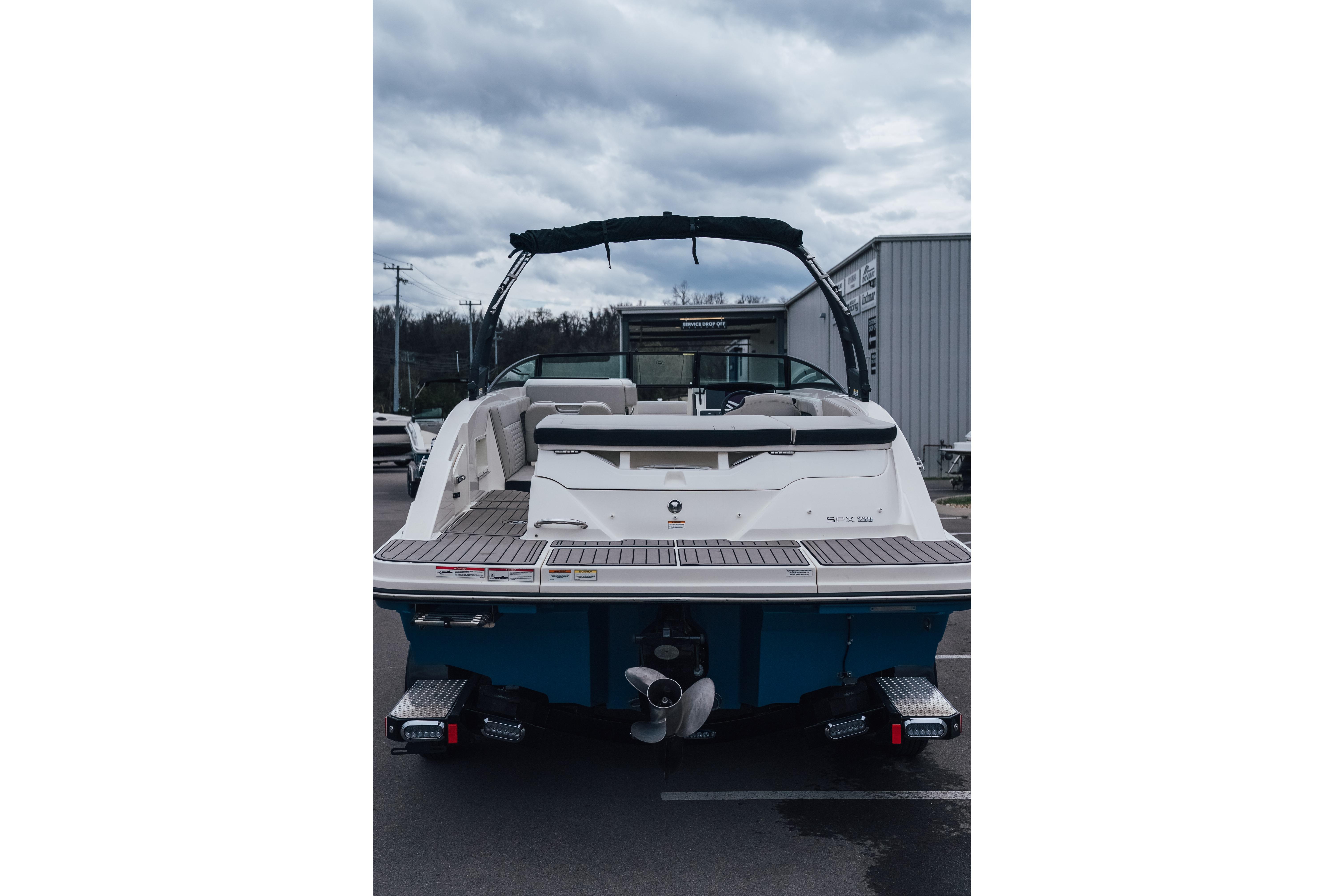 2023 Sea Ray SPX 230 boat, rear view, docked under cloudy skies.