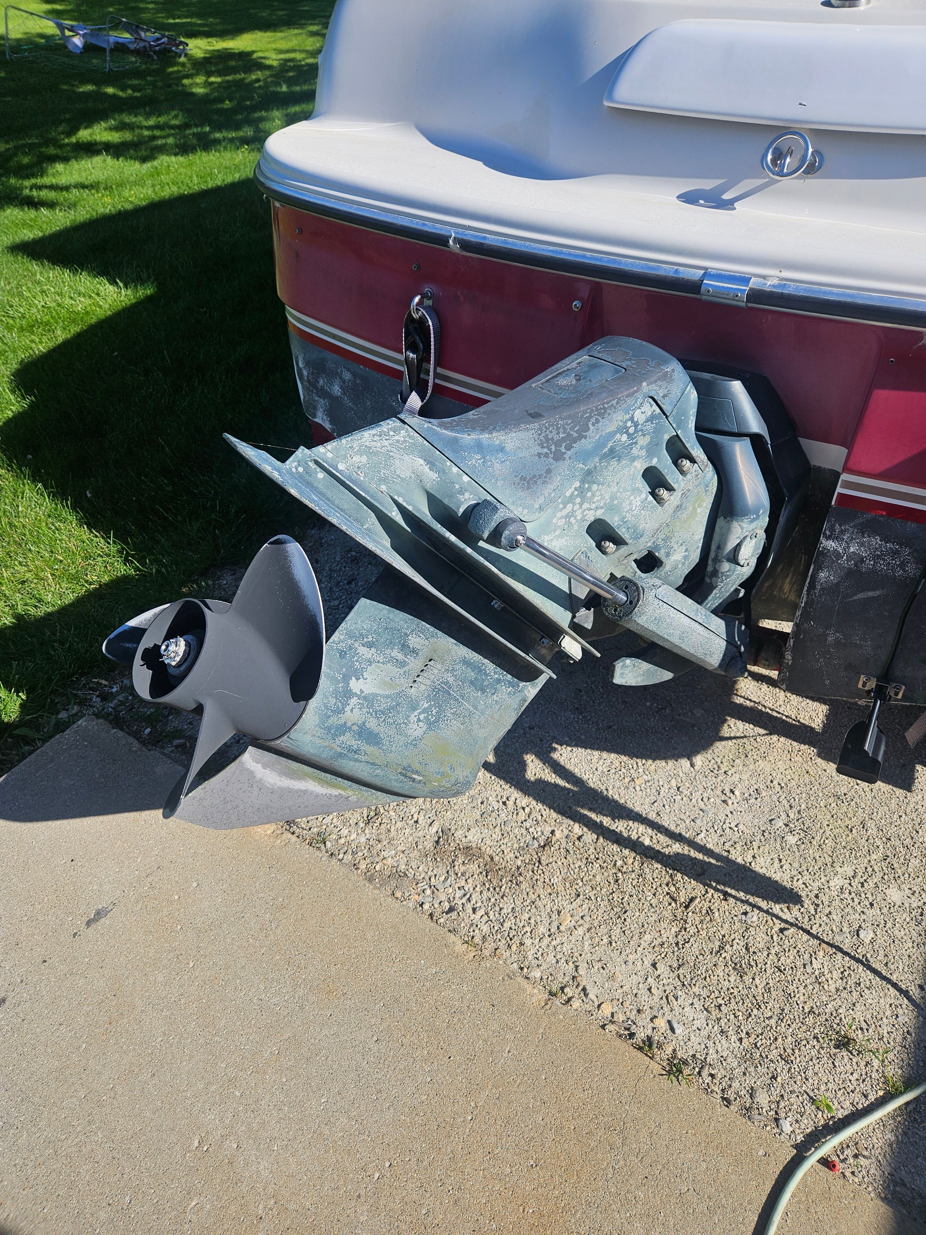 The image shows a boat's outboard motor on a concrete surface.