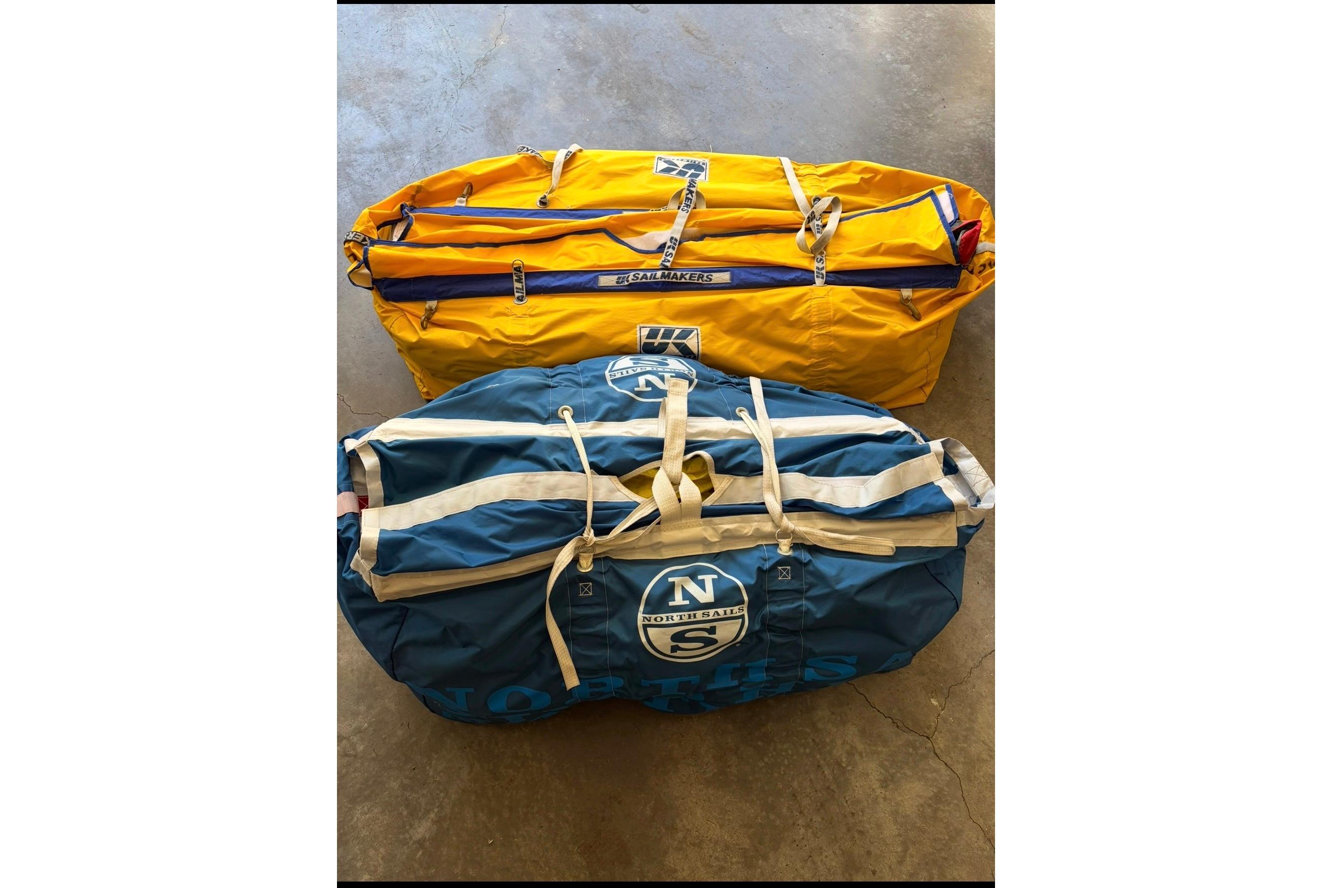 Yellow and blue sail bags on concrete floor, Hanse 418, 2022 model.