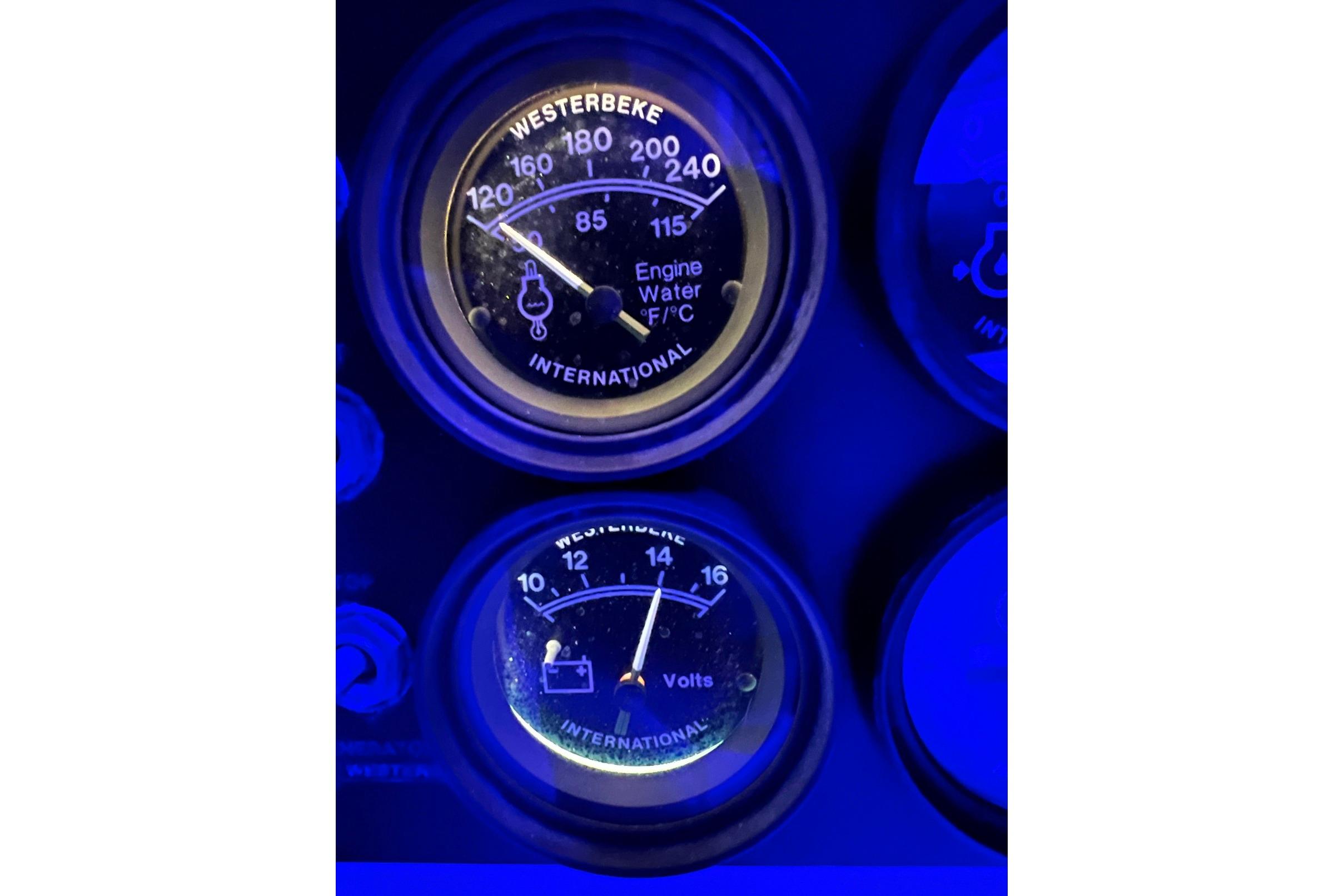Close-up of Luhrs 380 Open 1992 engine gauges illuminated in blue light.