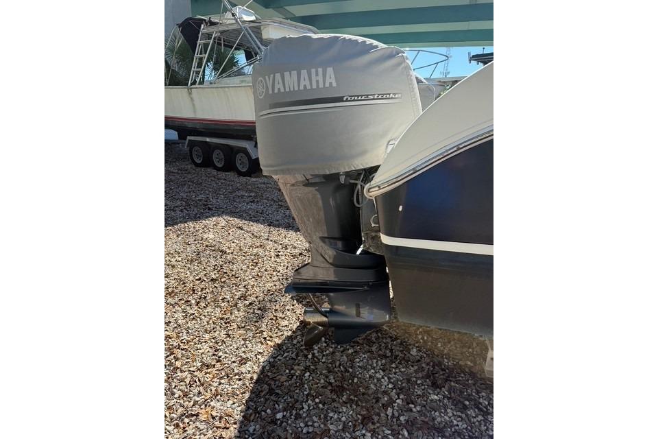 2003 World Cat 270 EC boat with Yamaha outboard motor, parked on gravel.