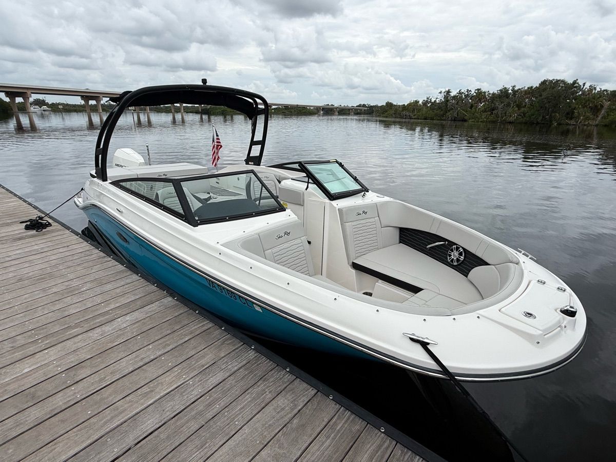 A 2024 Sea Ray SPX 230 Outboard docked at a wooden pier. It features a sleek, modern design.