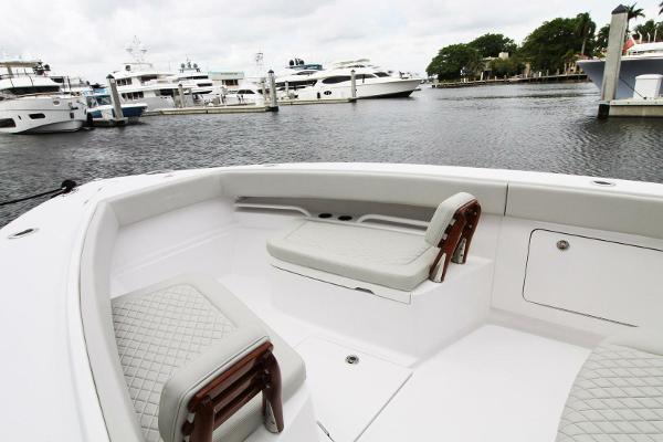 2024 Jupiter 34 HFS boat interior with cushioned seating, docked near luxury yachts.