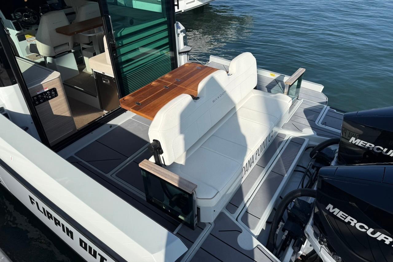 2024 Saxdor 320 GTC boat with seating area and twin Mercury engines on water.