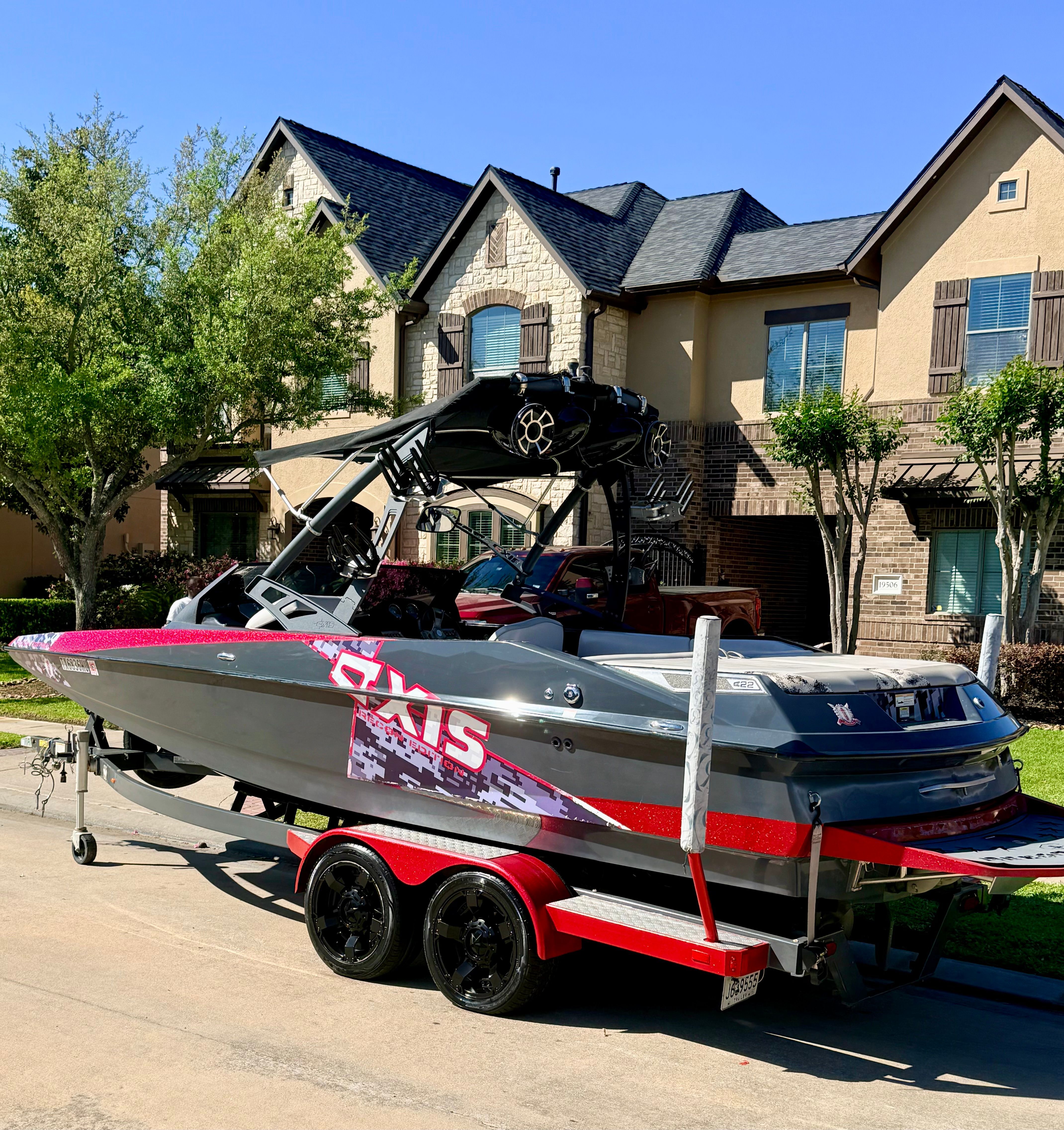 2013 Axis A22 boat on trailer in front of house.