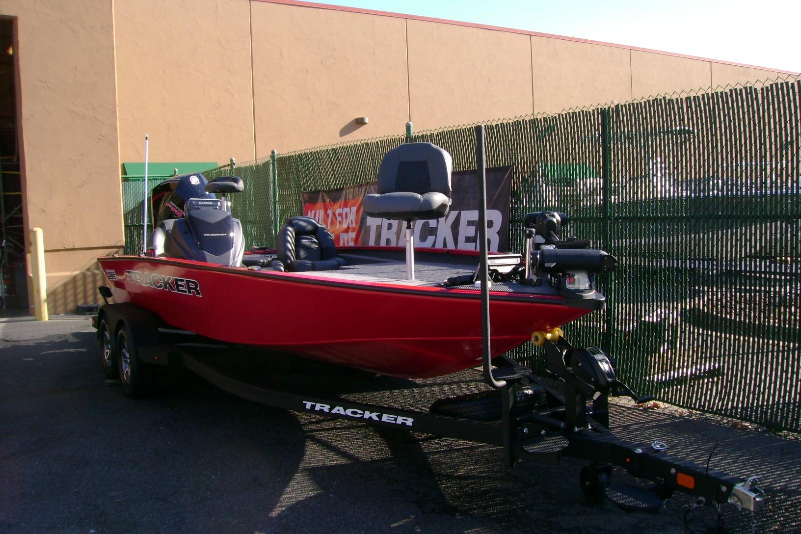 2026 Tracker Savage 215 boat in vibrant red on a trailer, parked outdoors.
