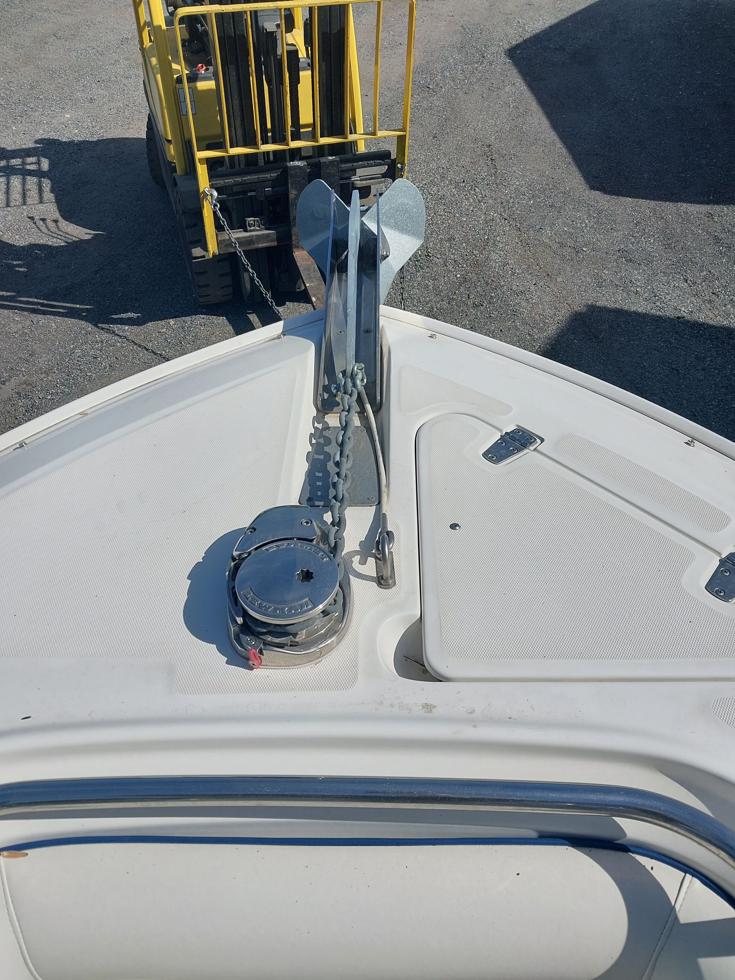 Bow view of a Boston Whaler 240 Outrage with anchor windlass and chain, on a trailer.