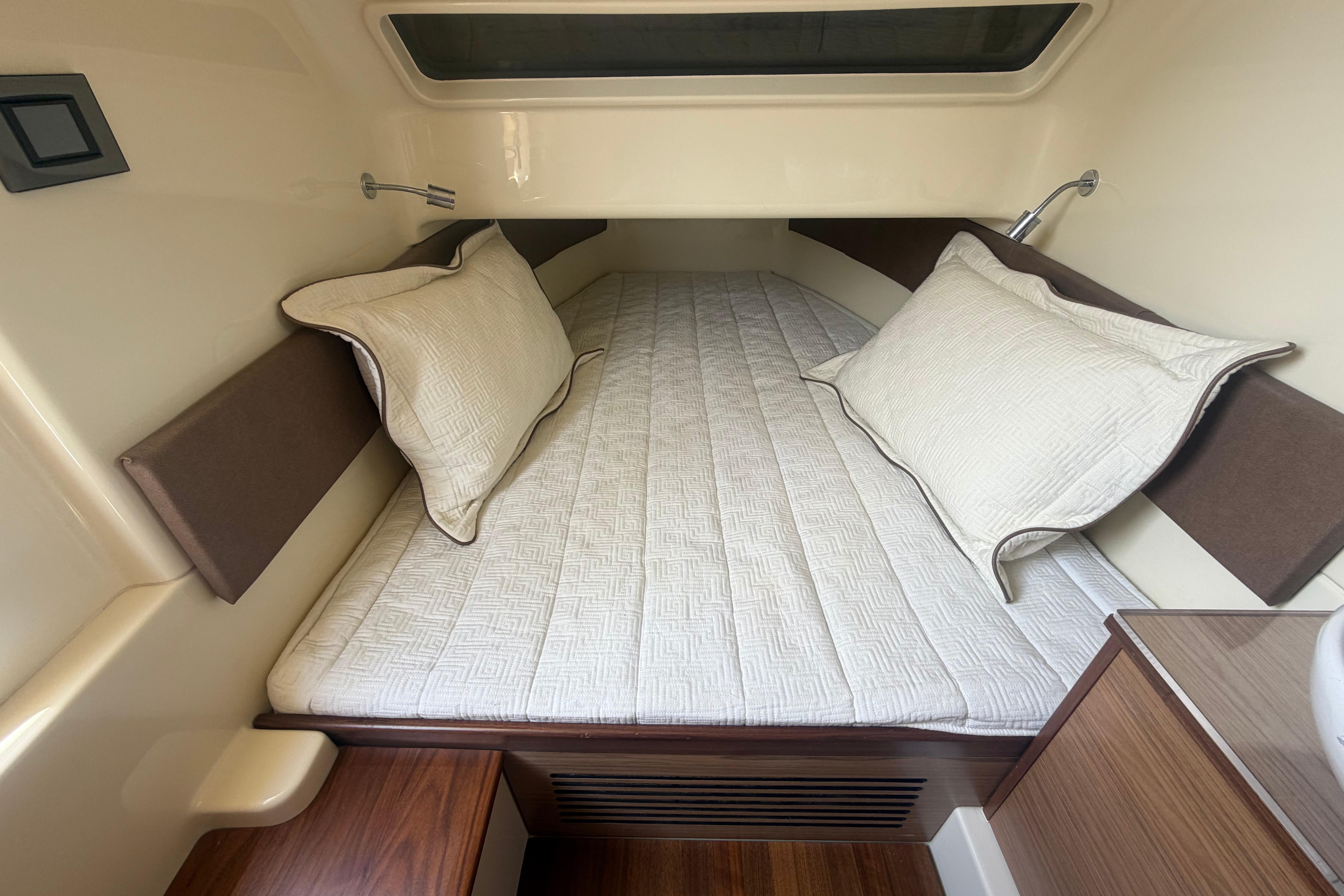 2017 Chris-Craft Catalina 34 cabin interior with cozy bed and pillows.