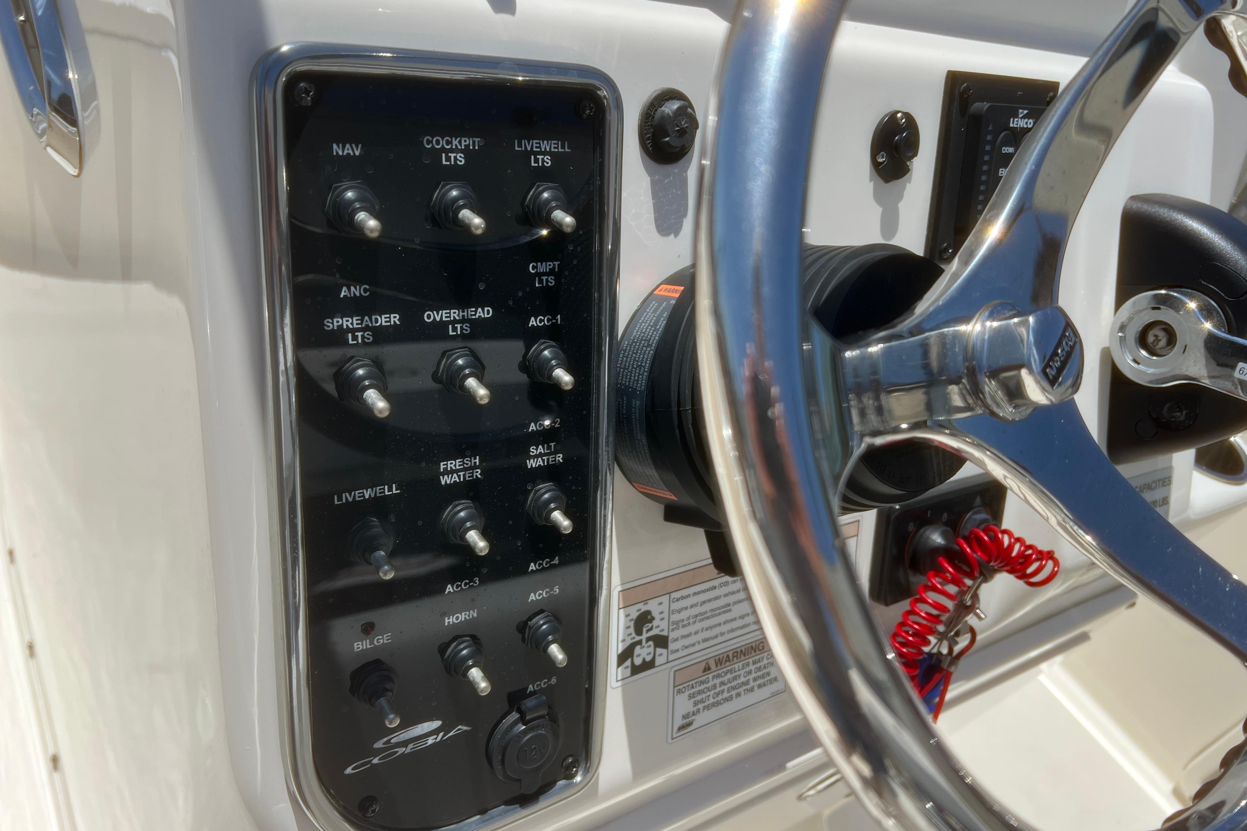 Control panel of a 2018 Cobia 201 Center Console boat with steering wheel.