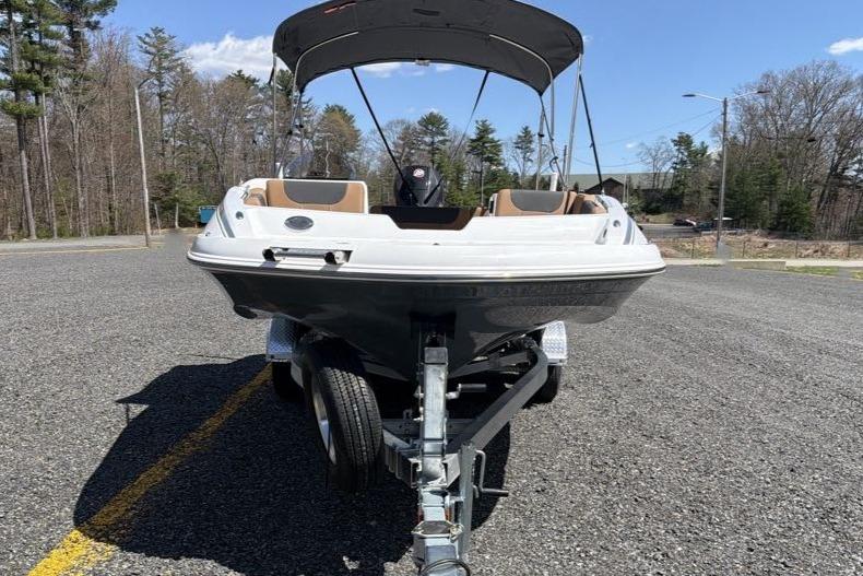 2026 Tahoe 1950 boat on trailer, parked on asphalt, under clear blue sky.