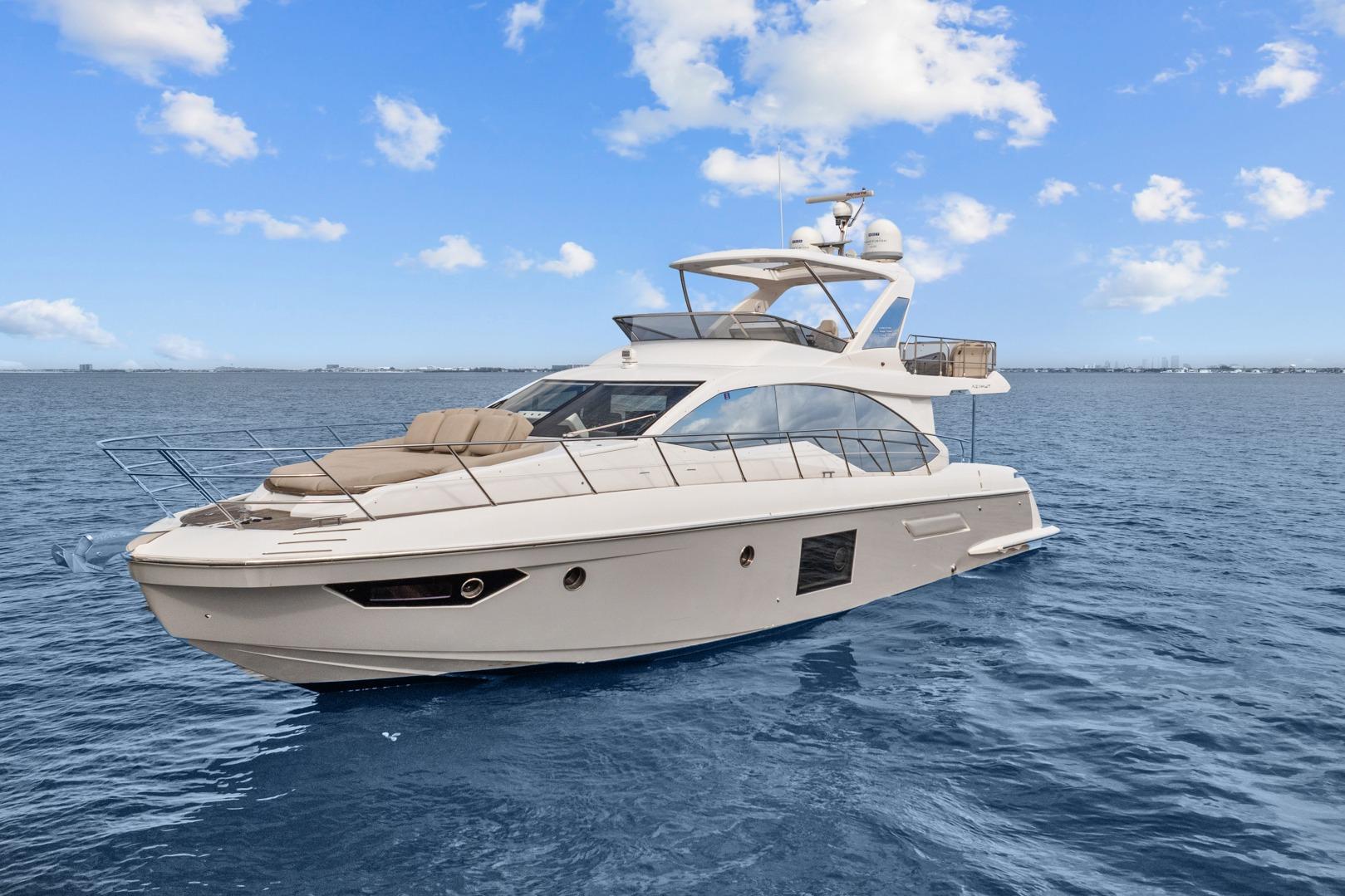 Luxury 2019 Azimut 55 yacht cruising on open sea under clear blue sky.