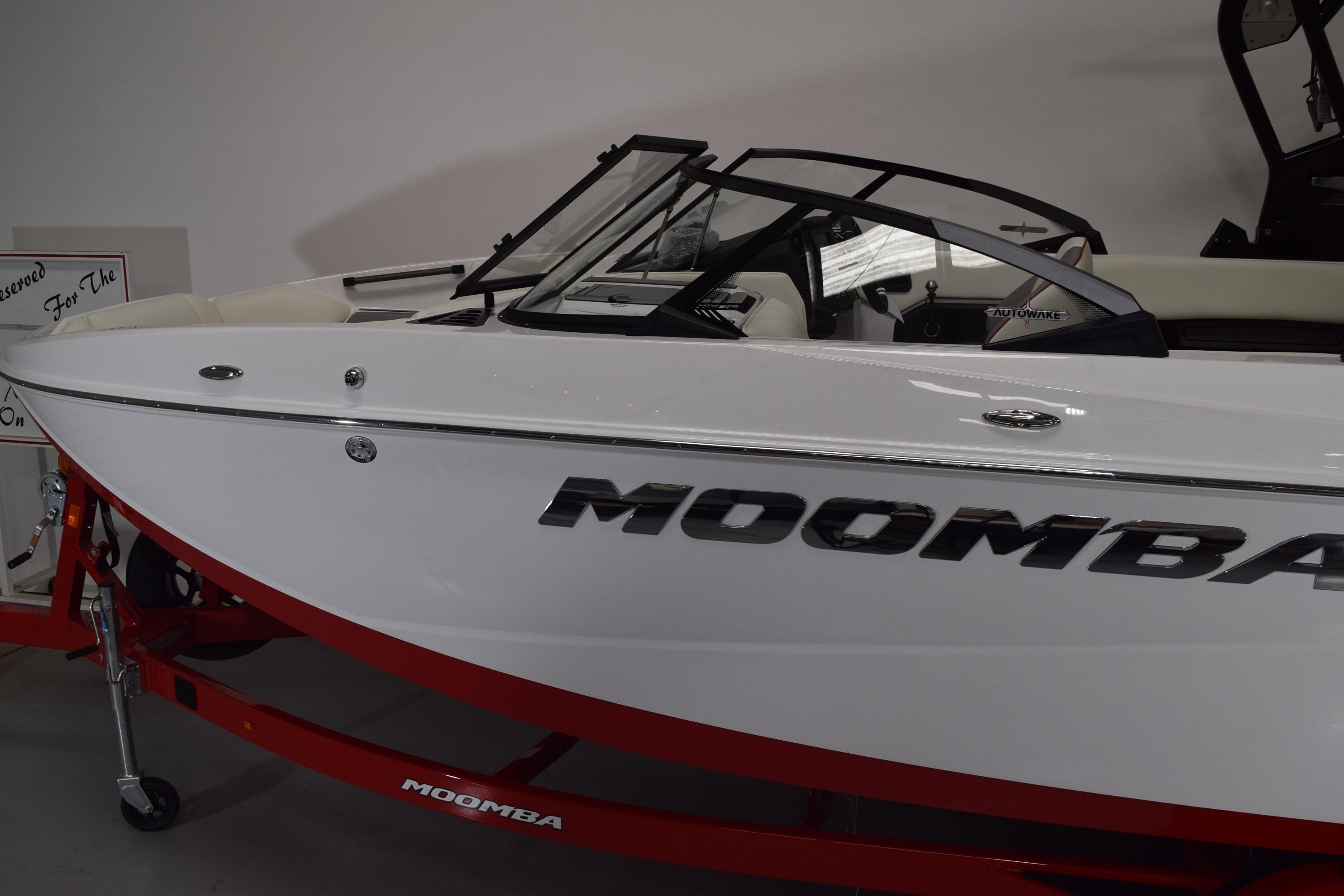 2026 Moomba Craz boat with sleek white design and red trailer.