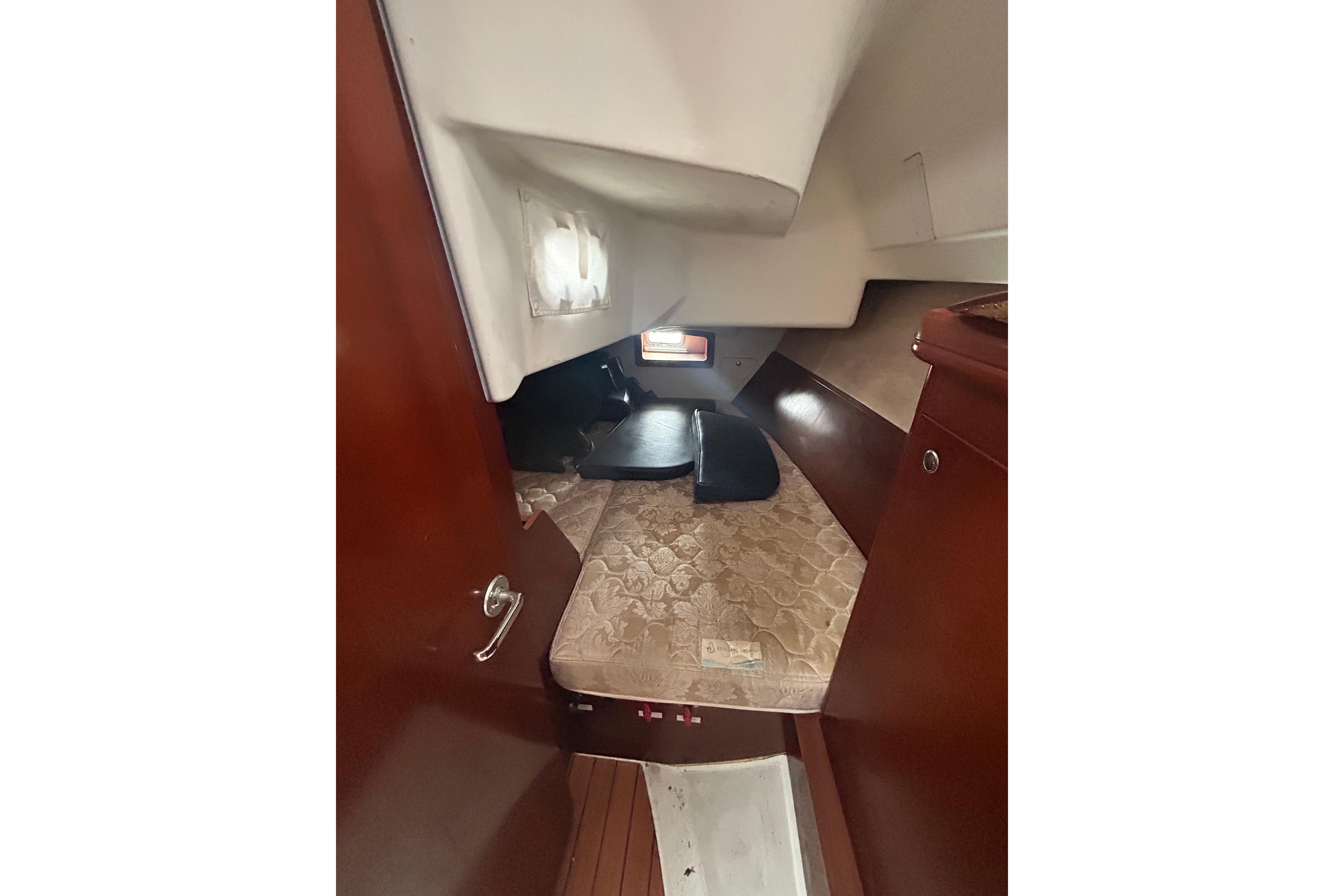 2006 Beneteau 343 cabin interior with wooden finish and cozy sleeping area.