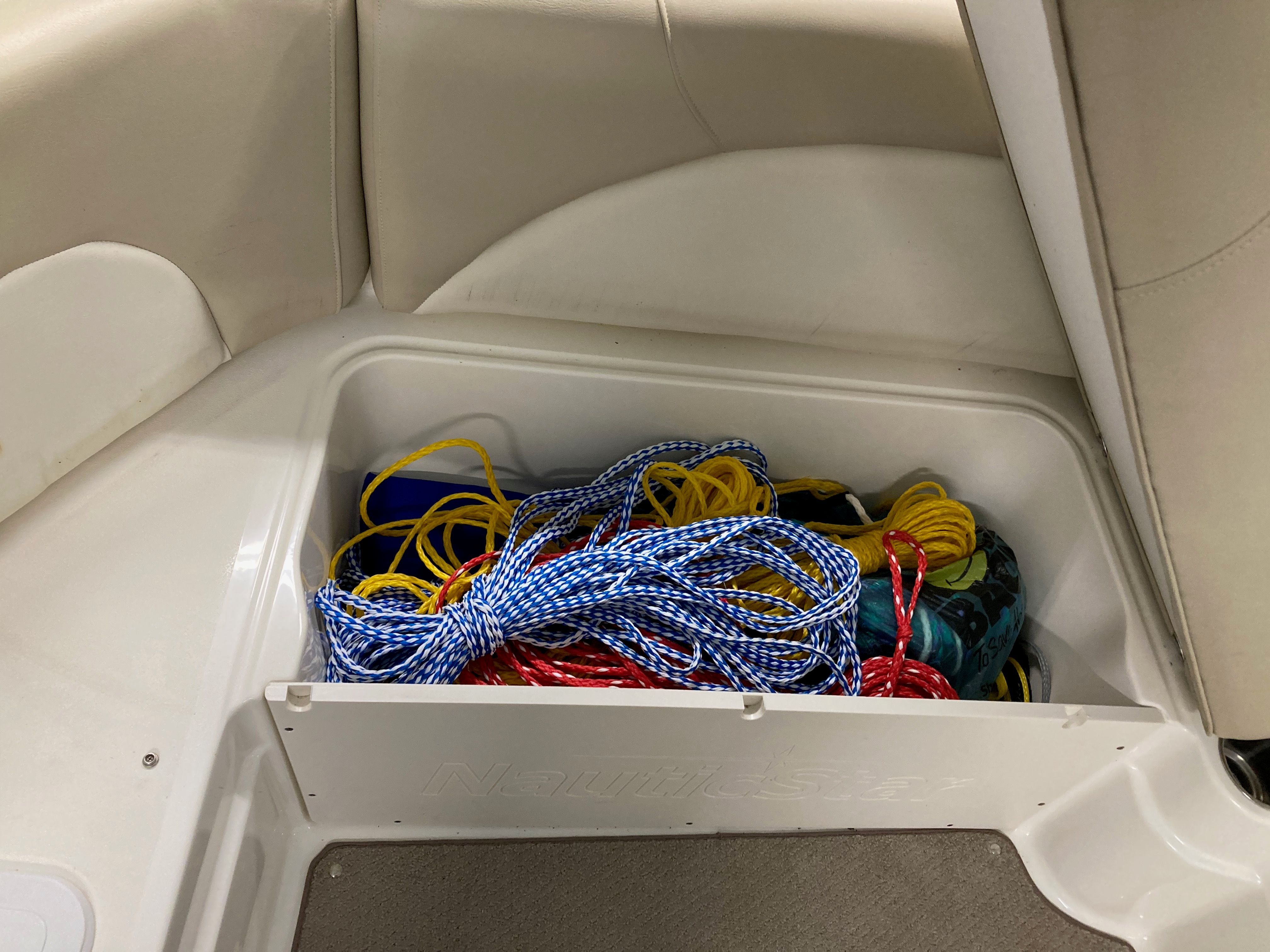 Boat storage compartment with various ropes and accessories.