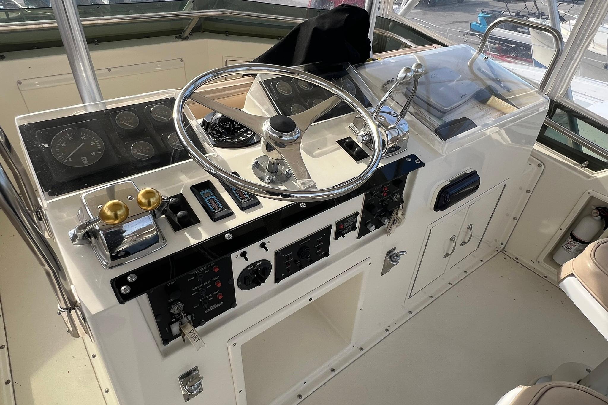 1990 Hatteras 41 Convertible yacht helm with steering wheel and control panel.