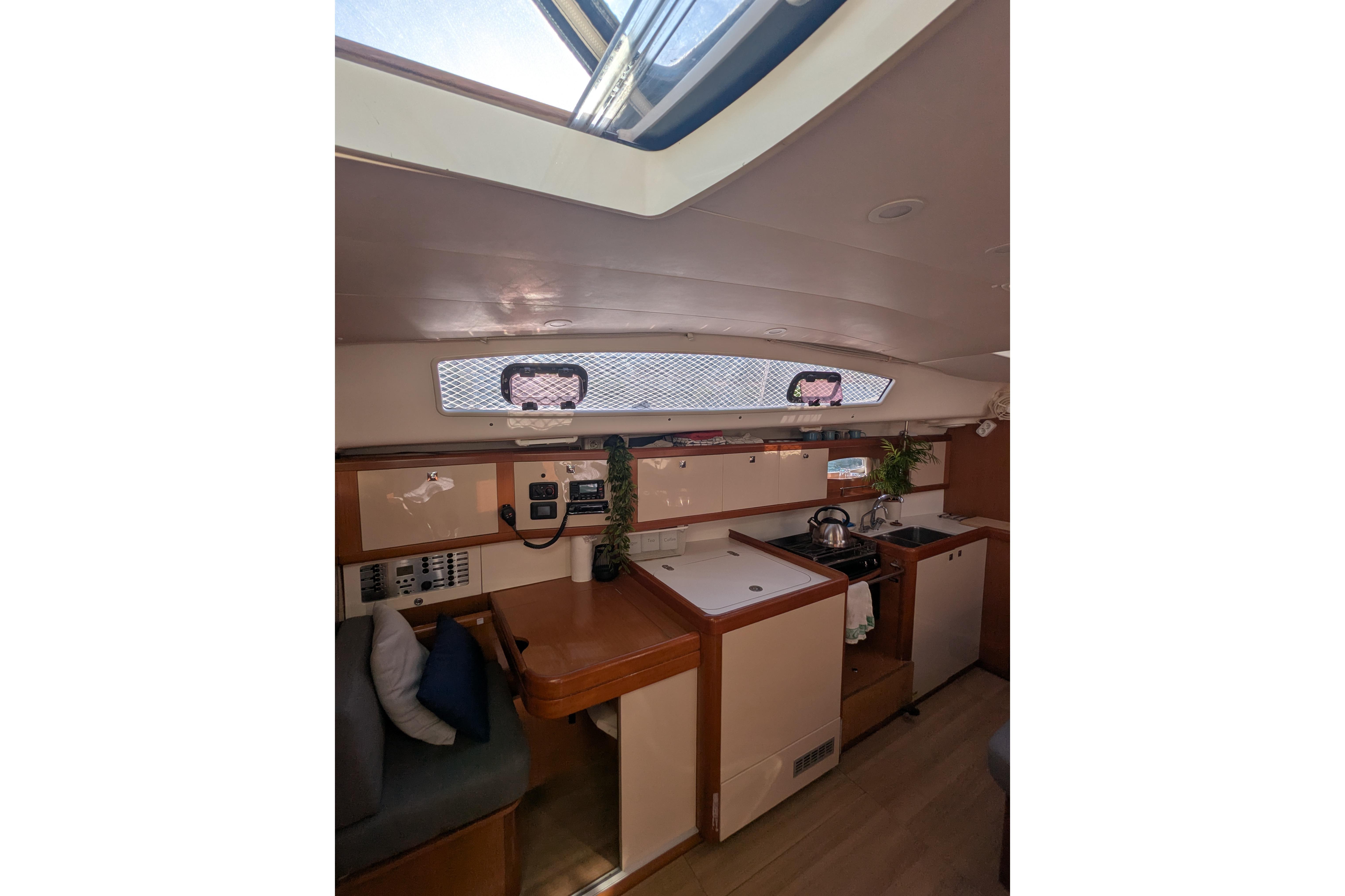 Interior of 2009 Beneteau Oceanis 40 yacht, featuring a compact kitchen and seating area.