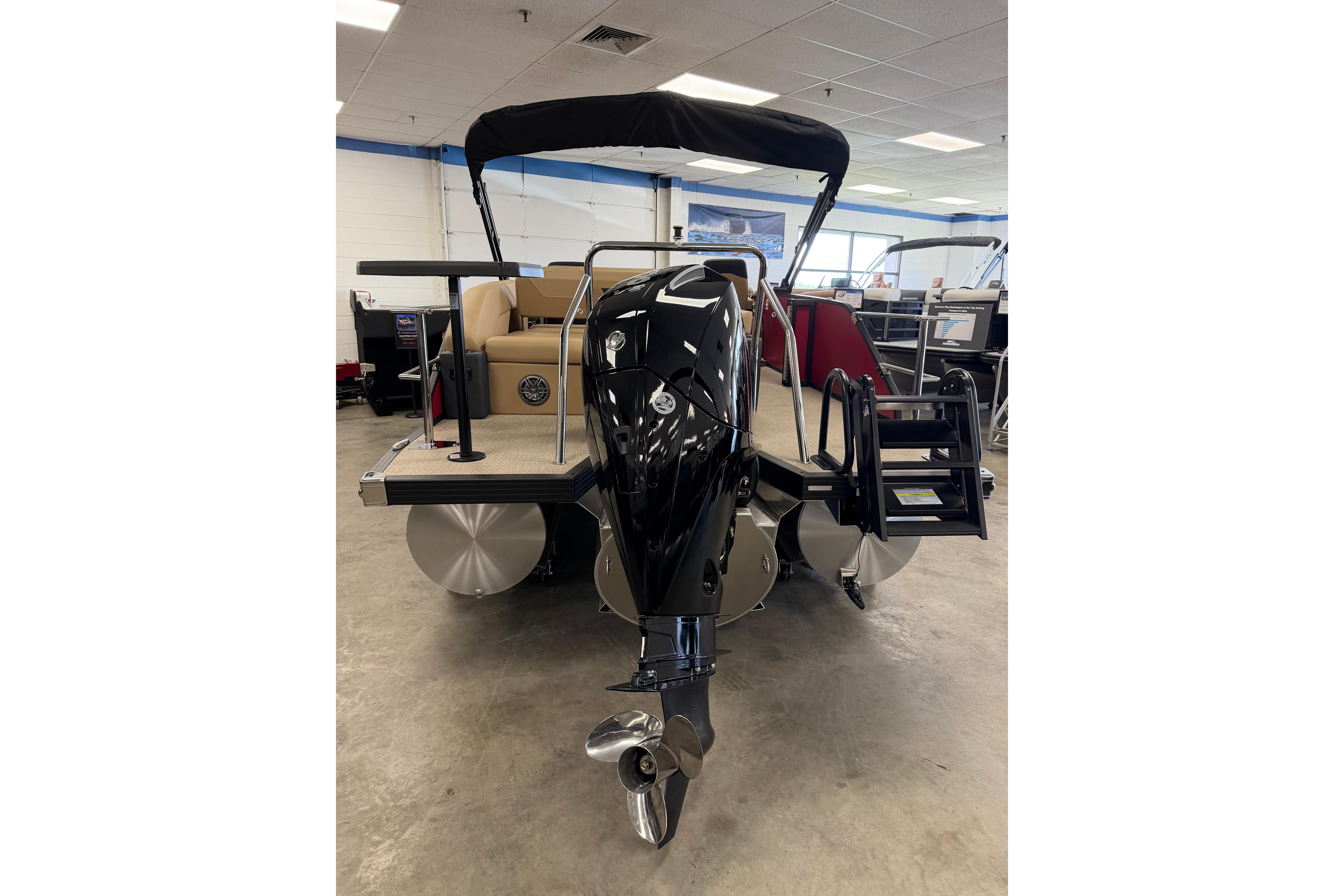 2026 Evotti 523CS pontoon boat with sleek black motor and spacious deck in showroom.
