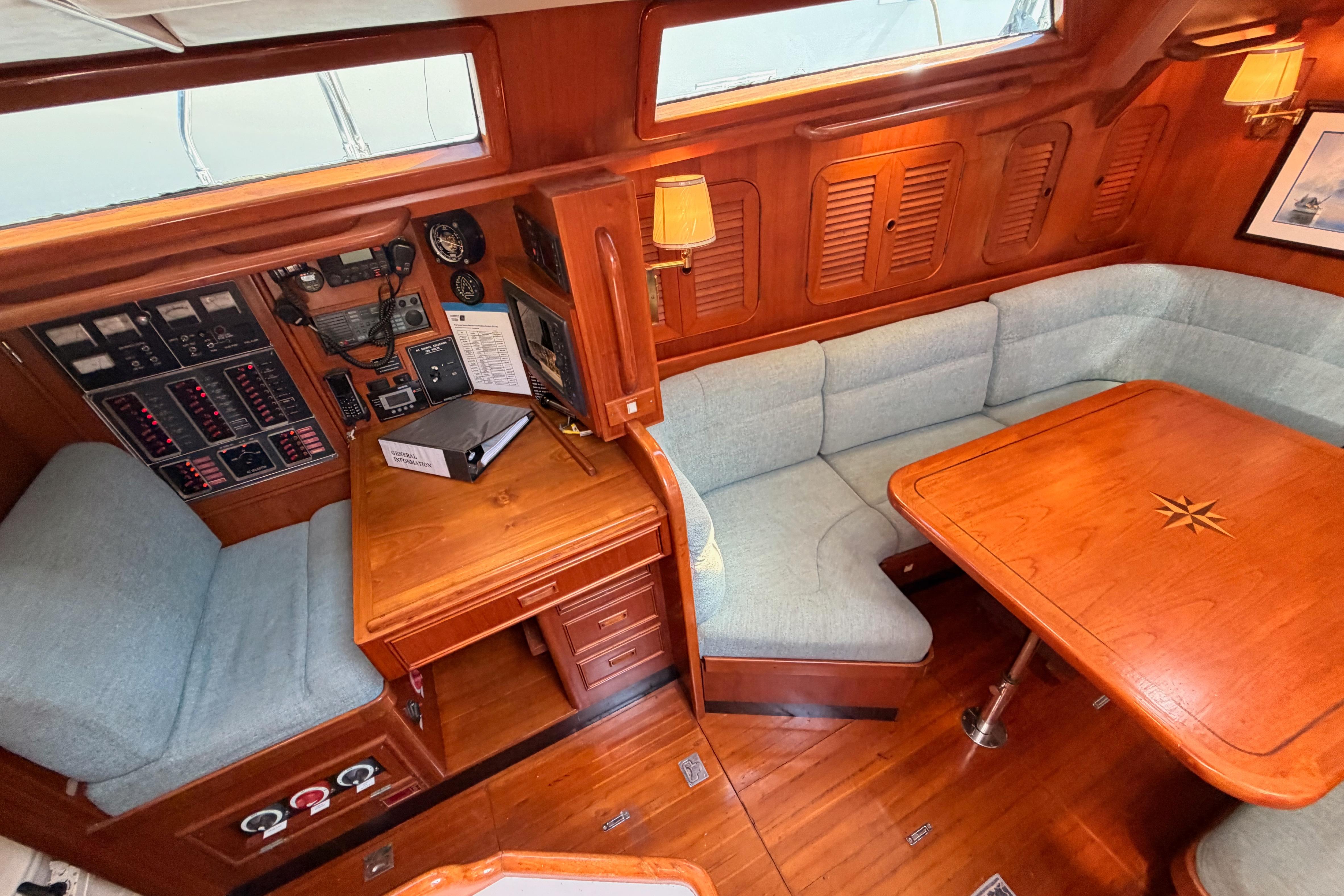 Cozy interior of 1991 Hylas 51 yacht with wooden furnishings and navigation equipment.