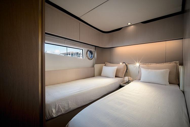 Luxurious twin bedroom in 2020 Azimut Fly 60 yacht, featuring modern design and cozy ambiance.