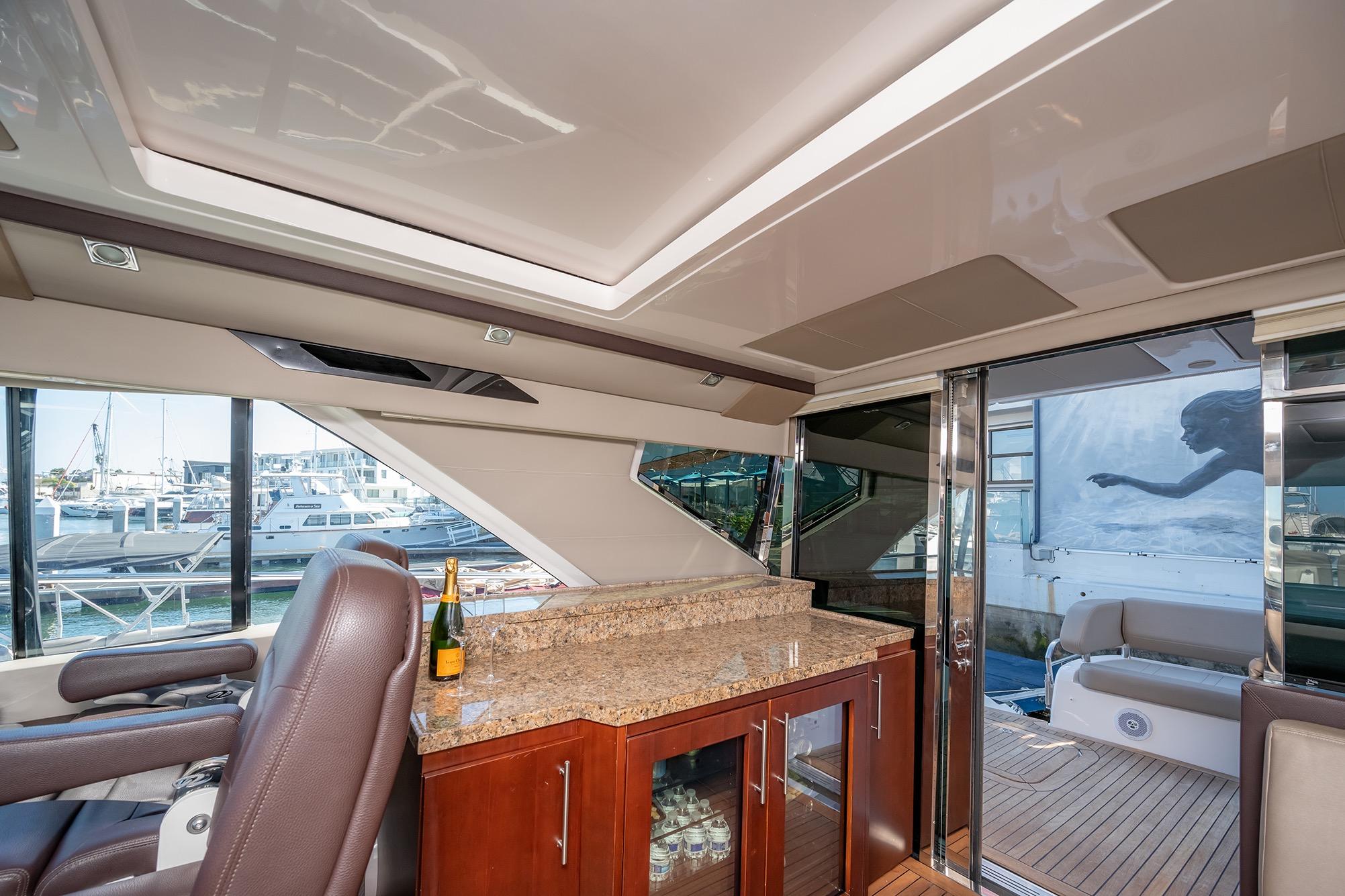 Luxurious interior of 2015 Regal 53 Sport Coupe yacht with granite countertop and marina view.