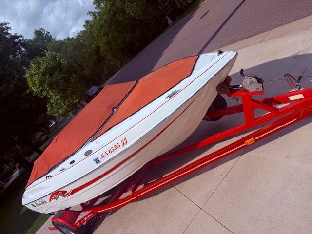 A 2001 Mariah Shabah boat on a red trailer, featuring an orange cover.