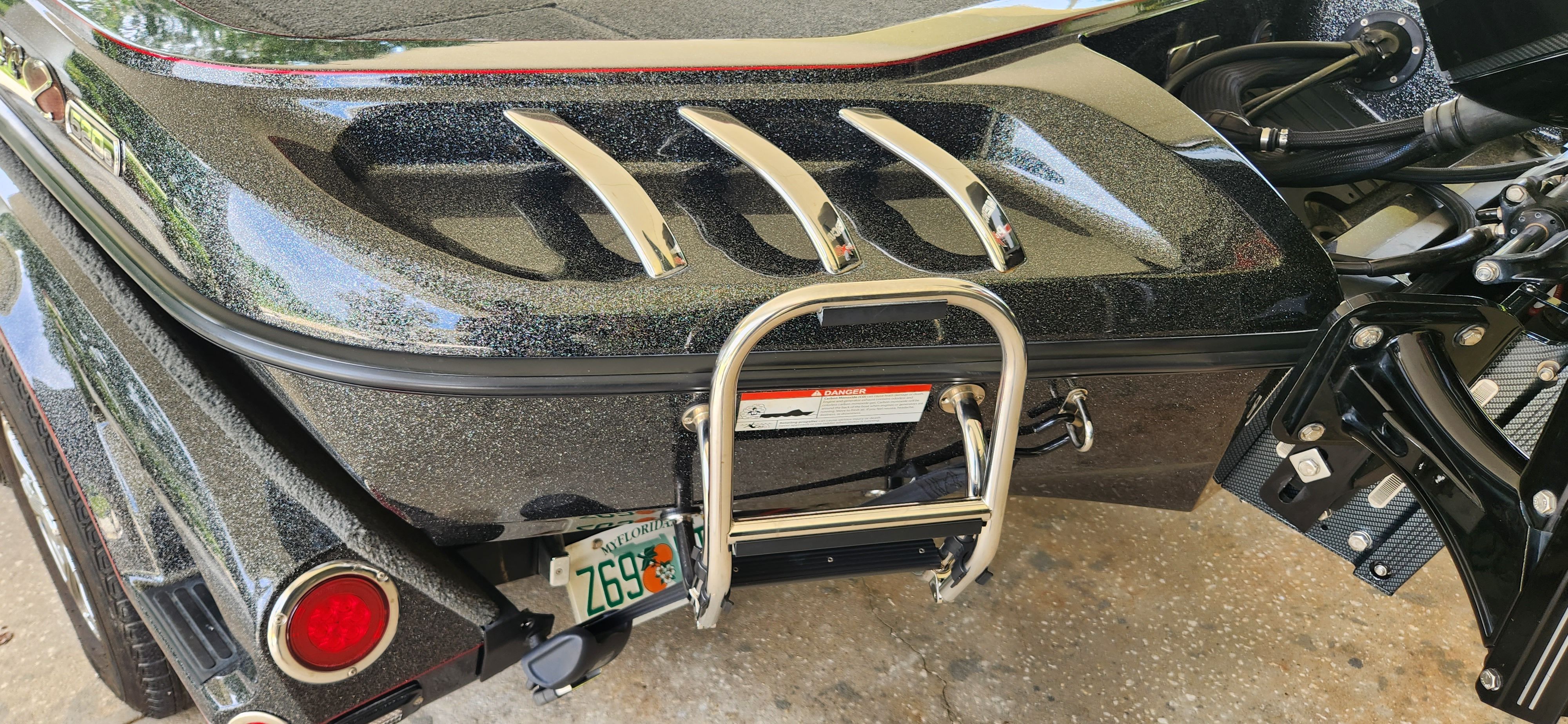 Close-up of the rear of a Ranger Z520 Comanche boat with ladder and engine.