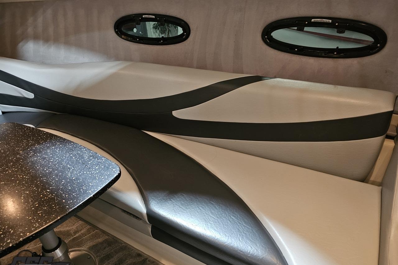 Interior of a 2008 Baja 335 Performance boat with stylish seating and oval windows.