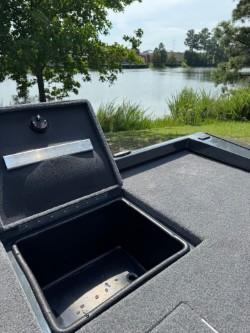 2025 Ranger RT198P boat with open storage compartment by the lake.