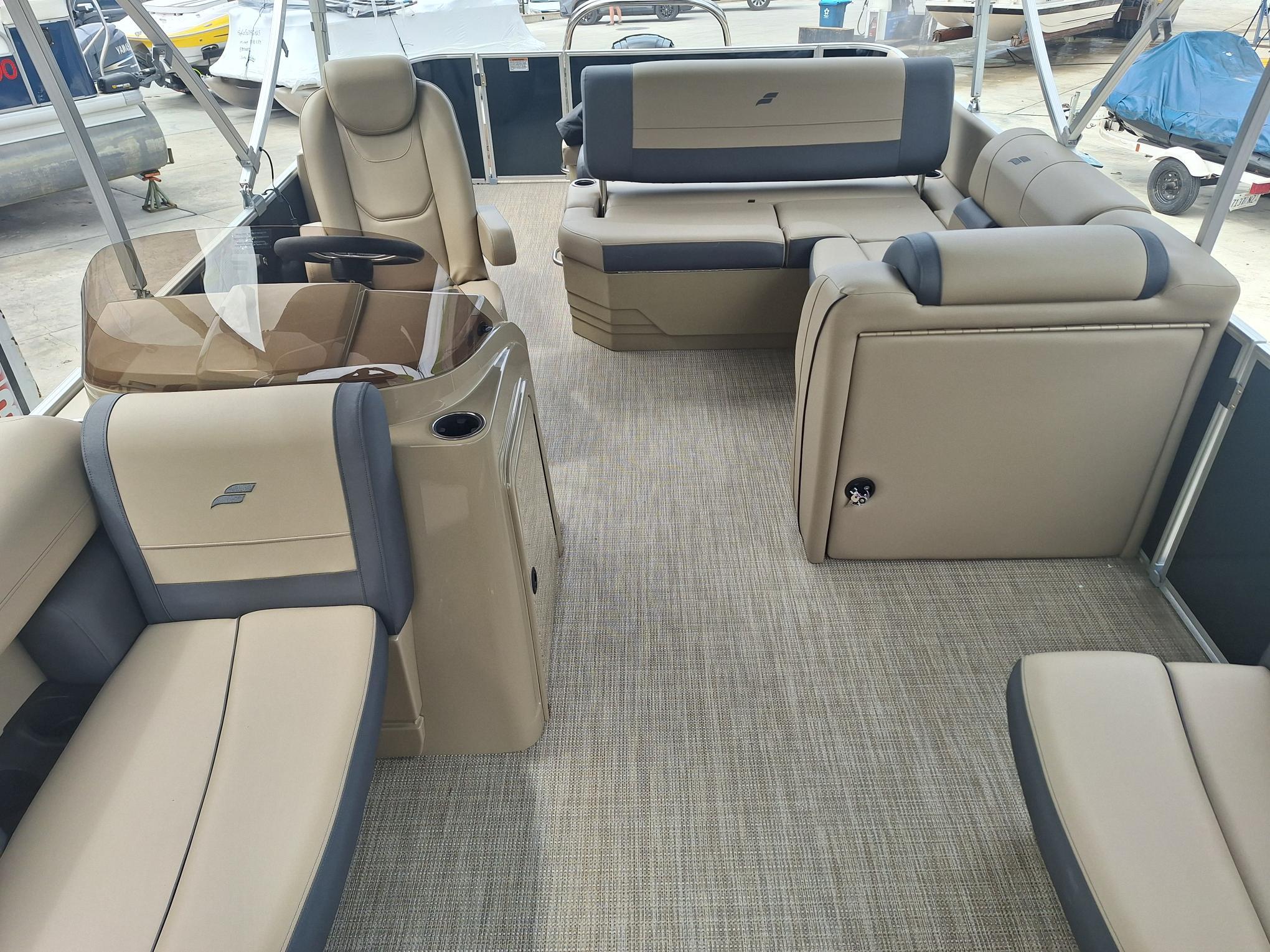 2024 Starcraft EX 22 Weekender boat interior with beige seating and carpeted flooring.