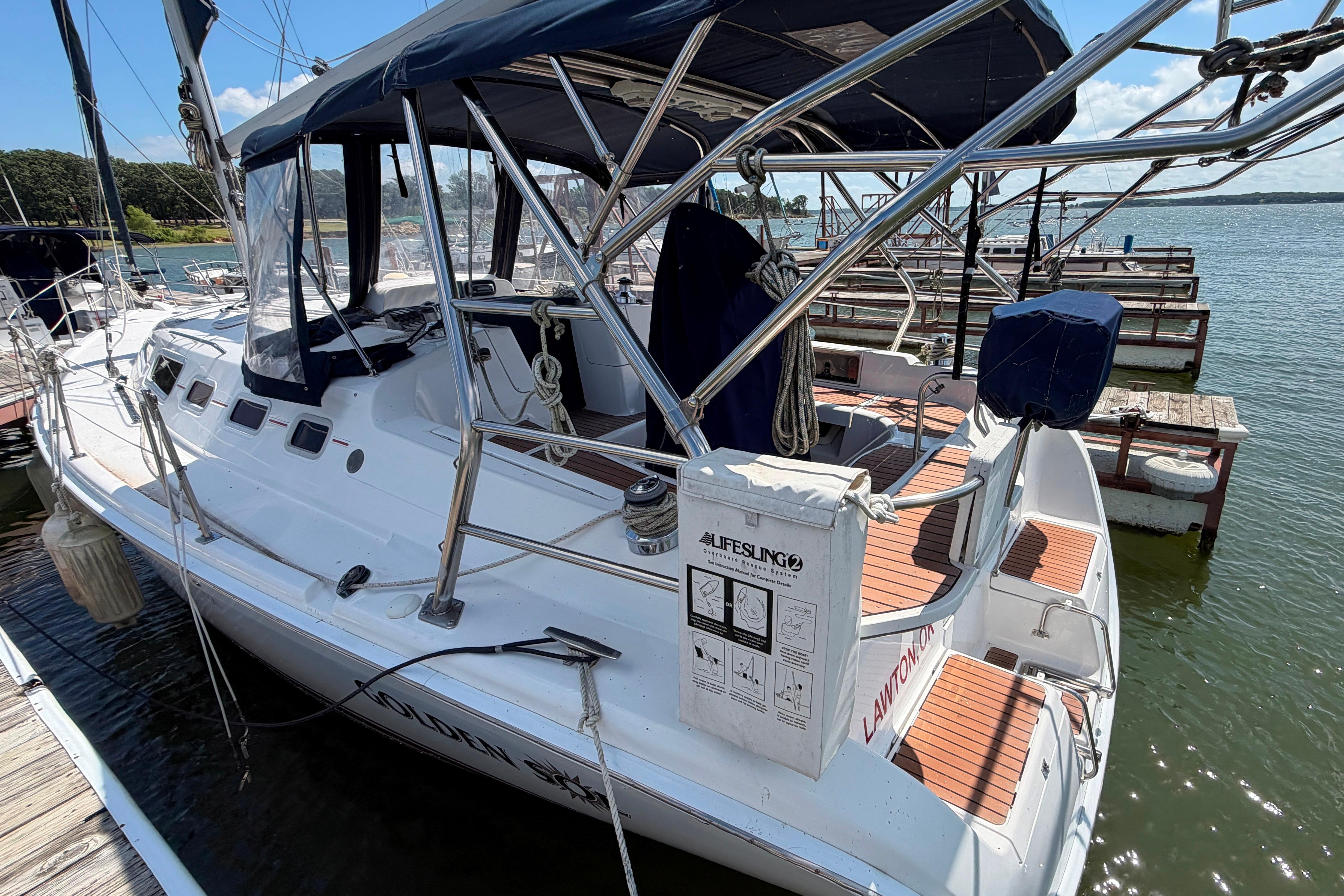 2005 Hunter 38 sailboat docked, featuring a spacious deck and protective canopy.