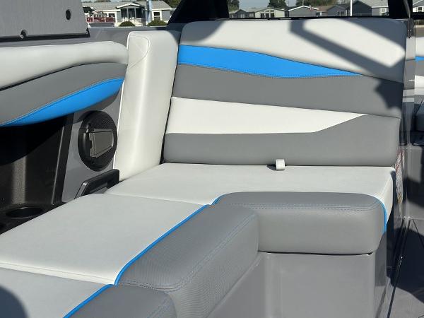 2025 Axis A225 boat interior with gray, white, and blue cushioned seating.