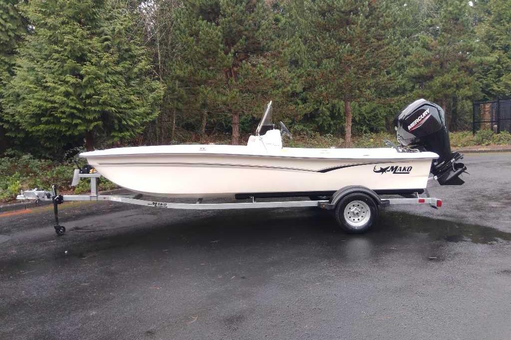 2026 Mako Pro Skiff 17 CC boat on trailer, parked outdoors near trees.