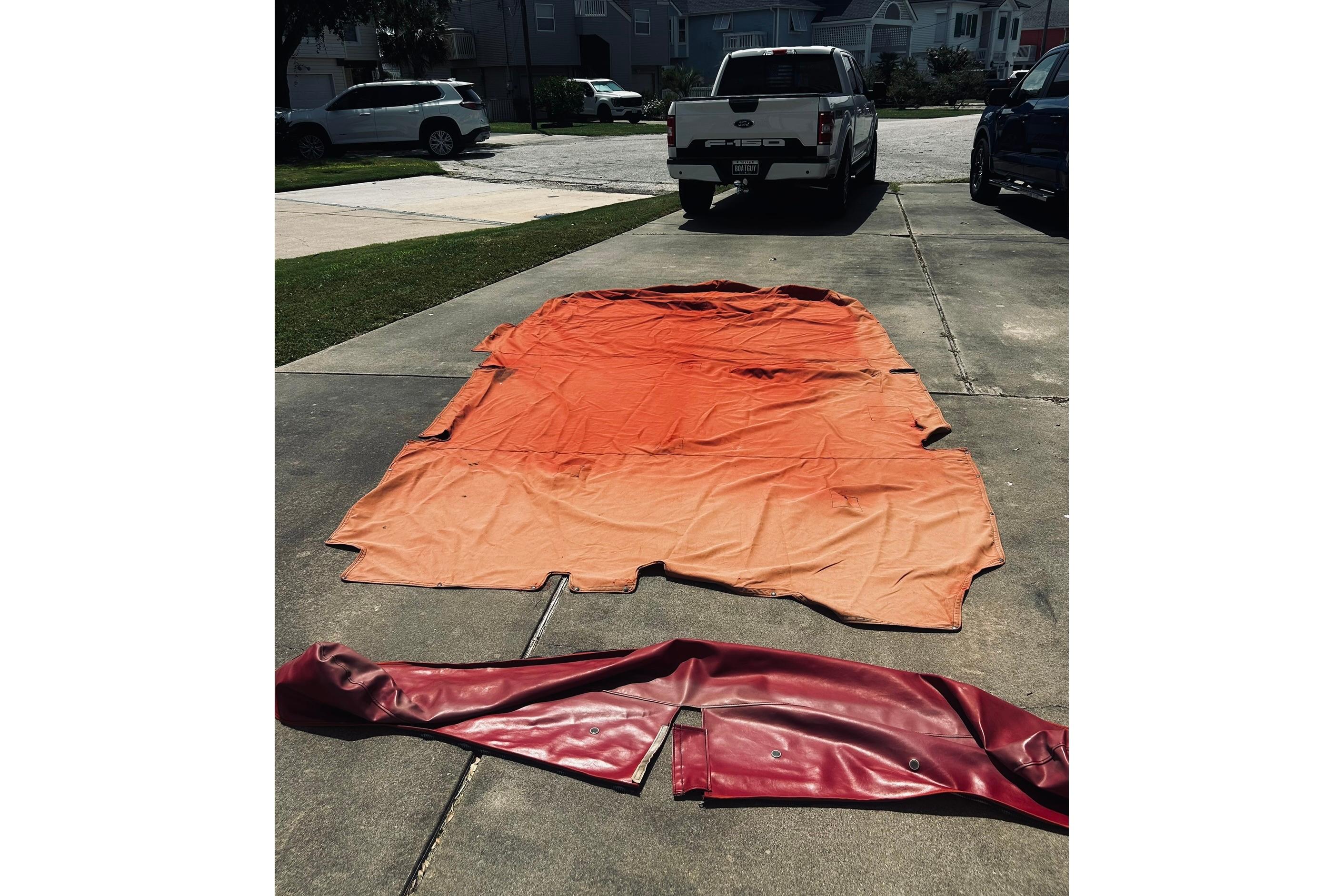 Orange and red boat cover on driveway, suitable for 2013 Hurricane SunDeck Sport 201 OB.