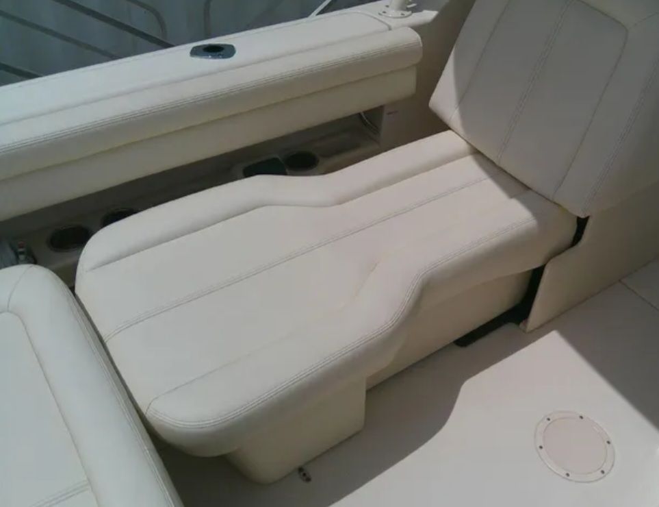 The image shows a beige lounging area on a boat, surrounded by seating.