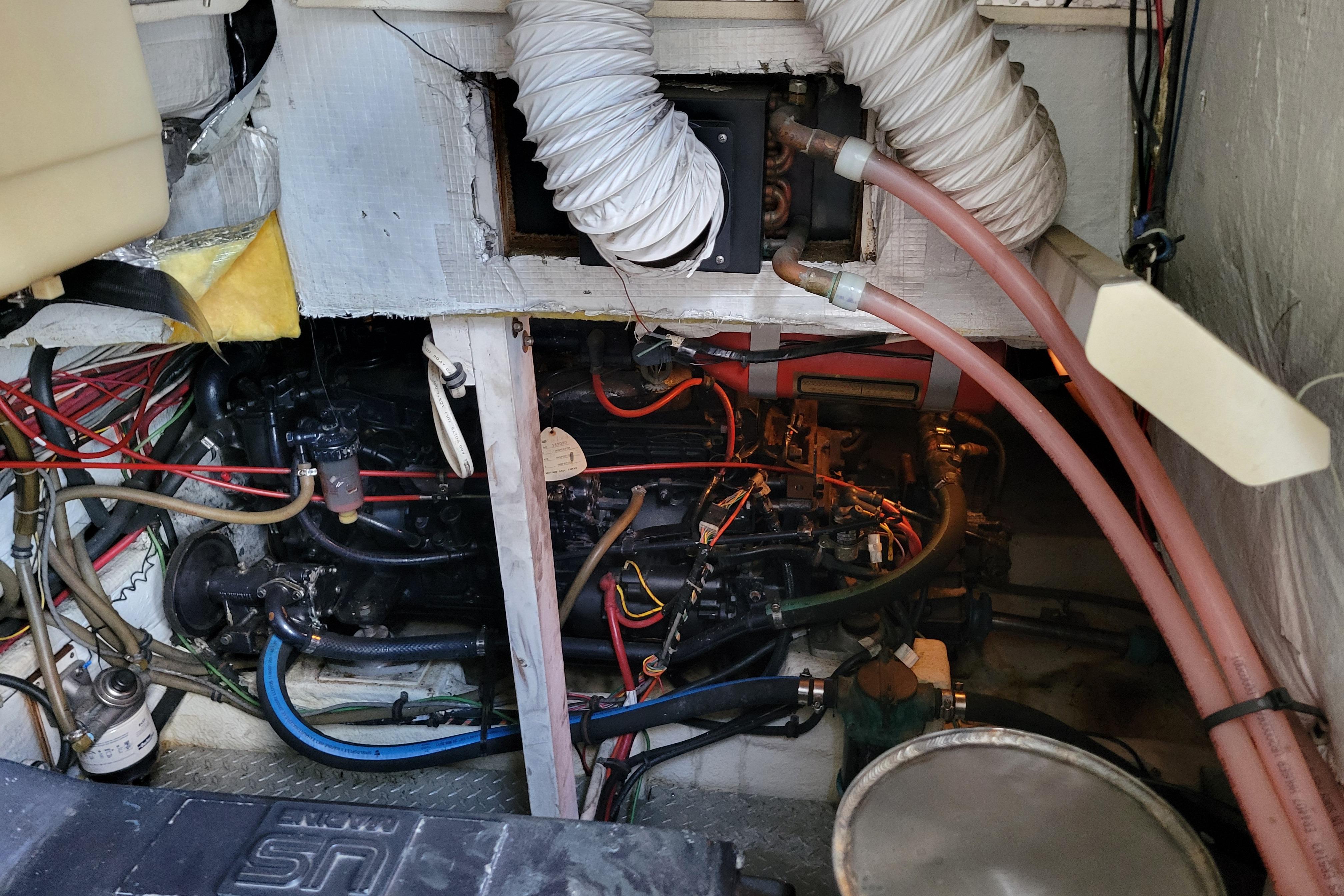 Engine room of 1989 Bayliner 3888 Motoryacht with visible wiring and hoses.