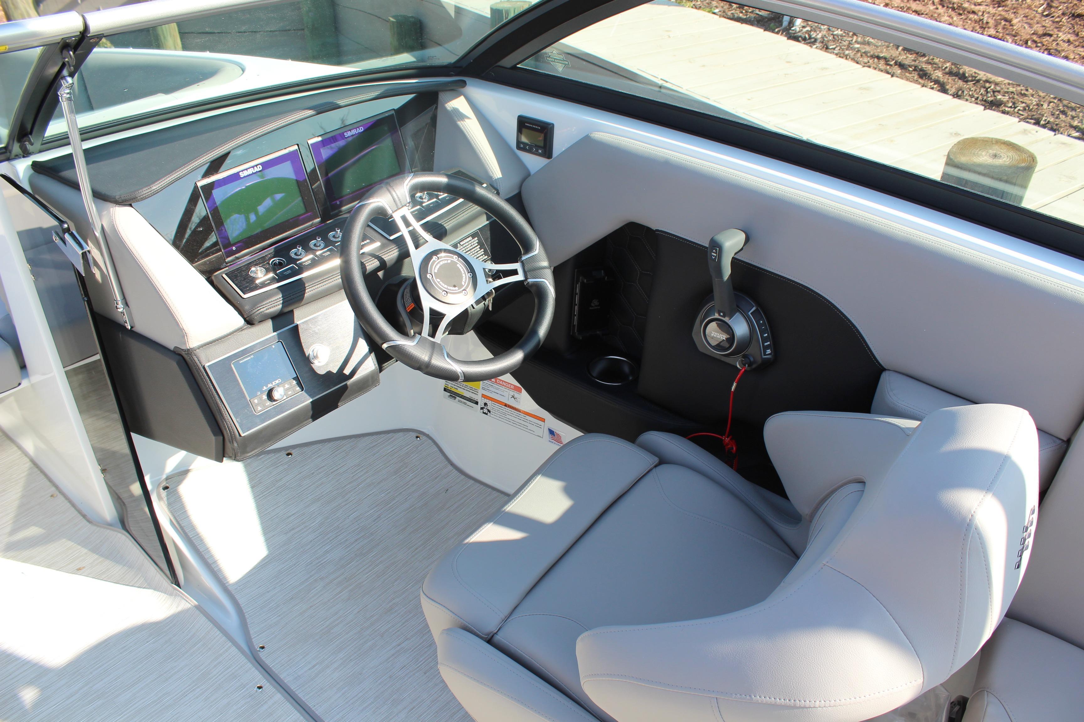 2026 Four Winns H4 boat cockpit with modern steering and control panel.