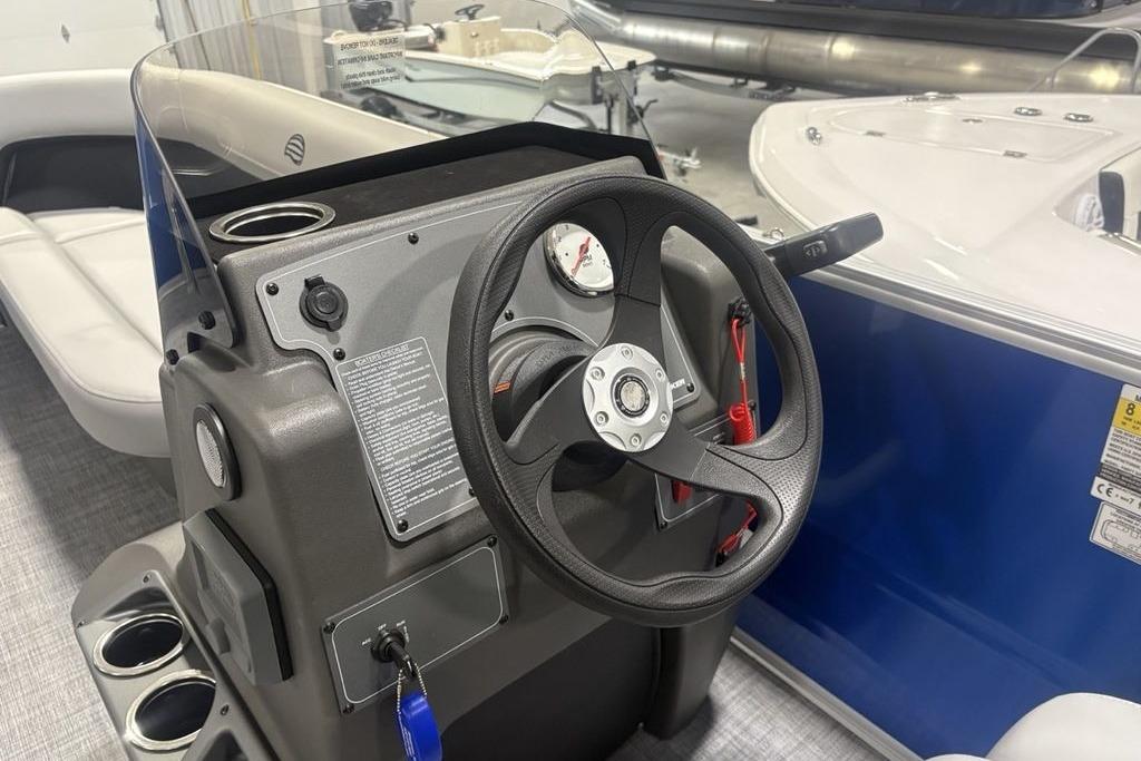 2026 Sun Tracker Party Barge 16 DLX steering console with cup holders and gauges.