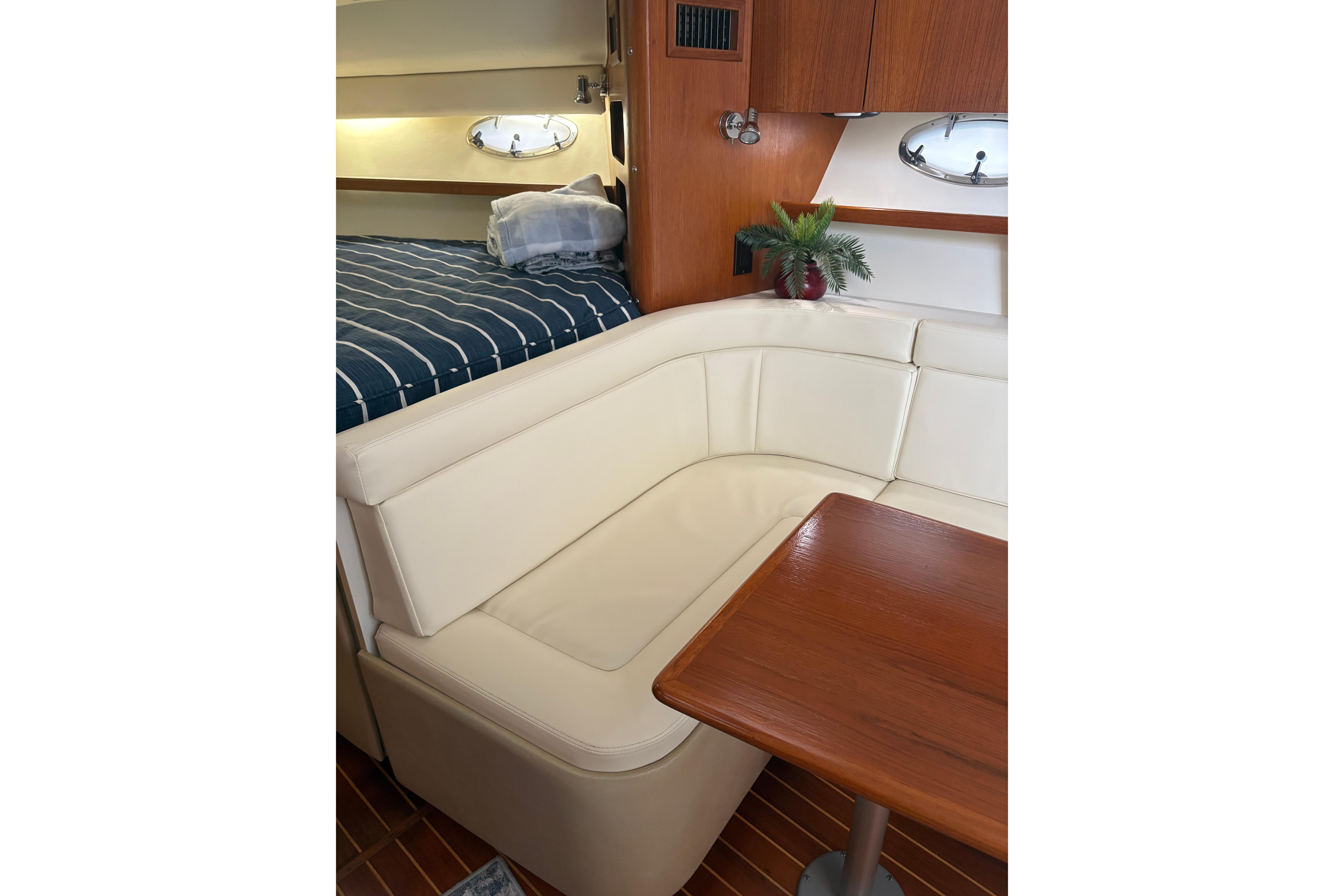 Interior of 1999 Tiara Yachts 3100 Open with cream seating and wooden table.