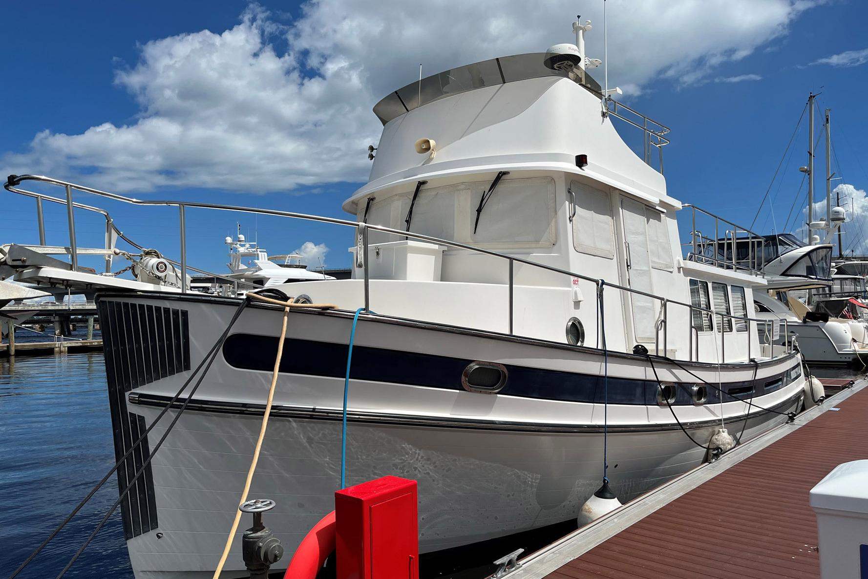 2007 Nordic Tug 42 docked at marina under blue sky.