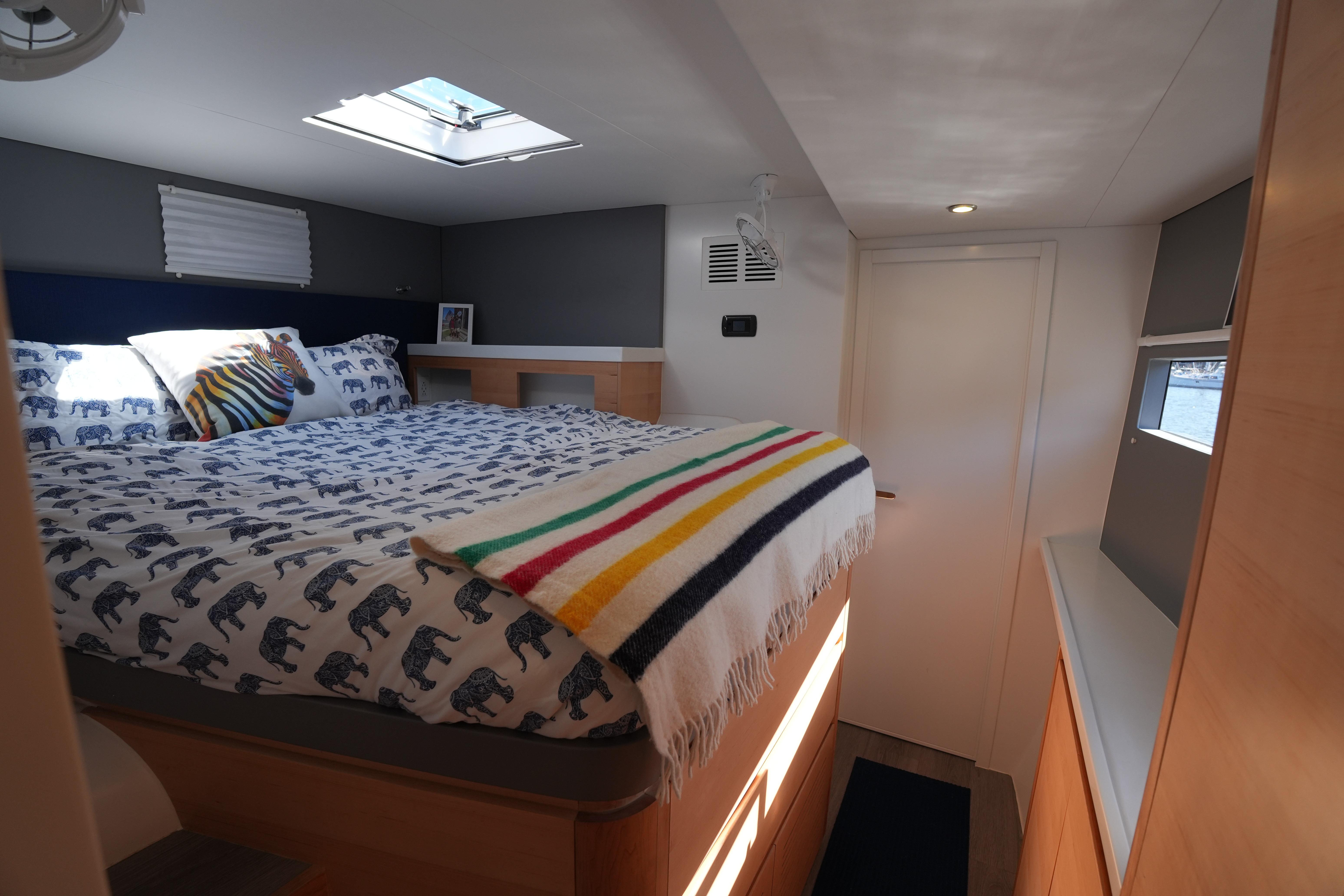 Cozy bedroom in 2024 Balance 442 yacht with skylight and colorful bedding.