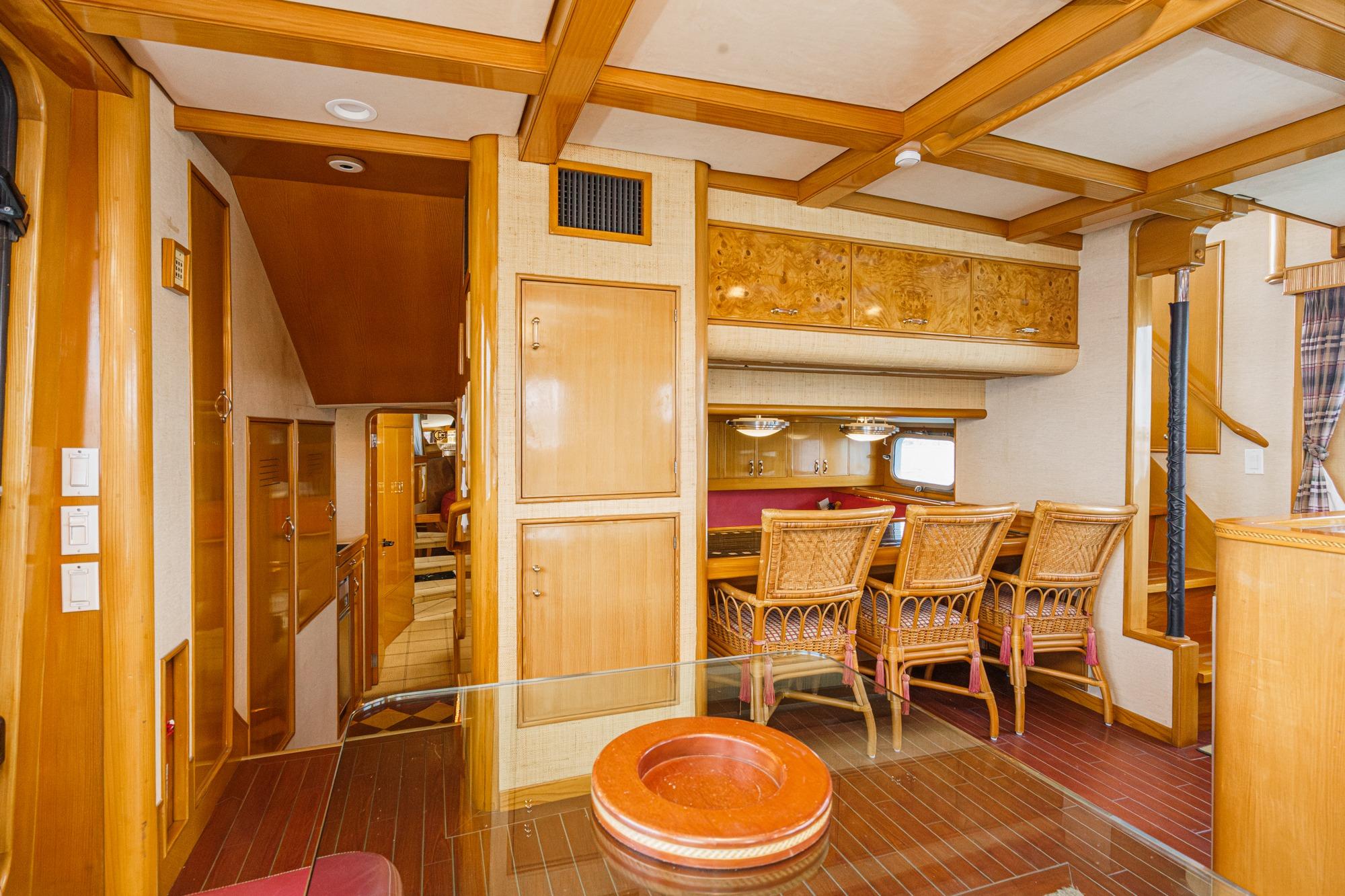 Luxurious interior of a 1990 Seaton Long Range Cruiser with wooden furnishings and dining area.