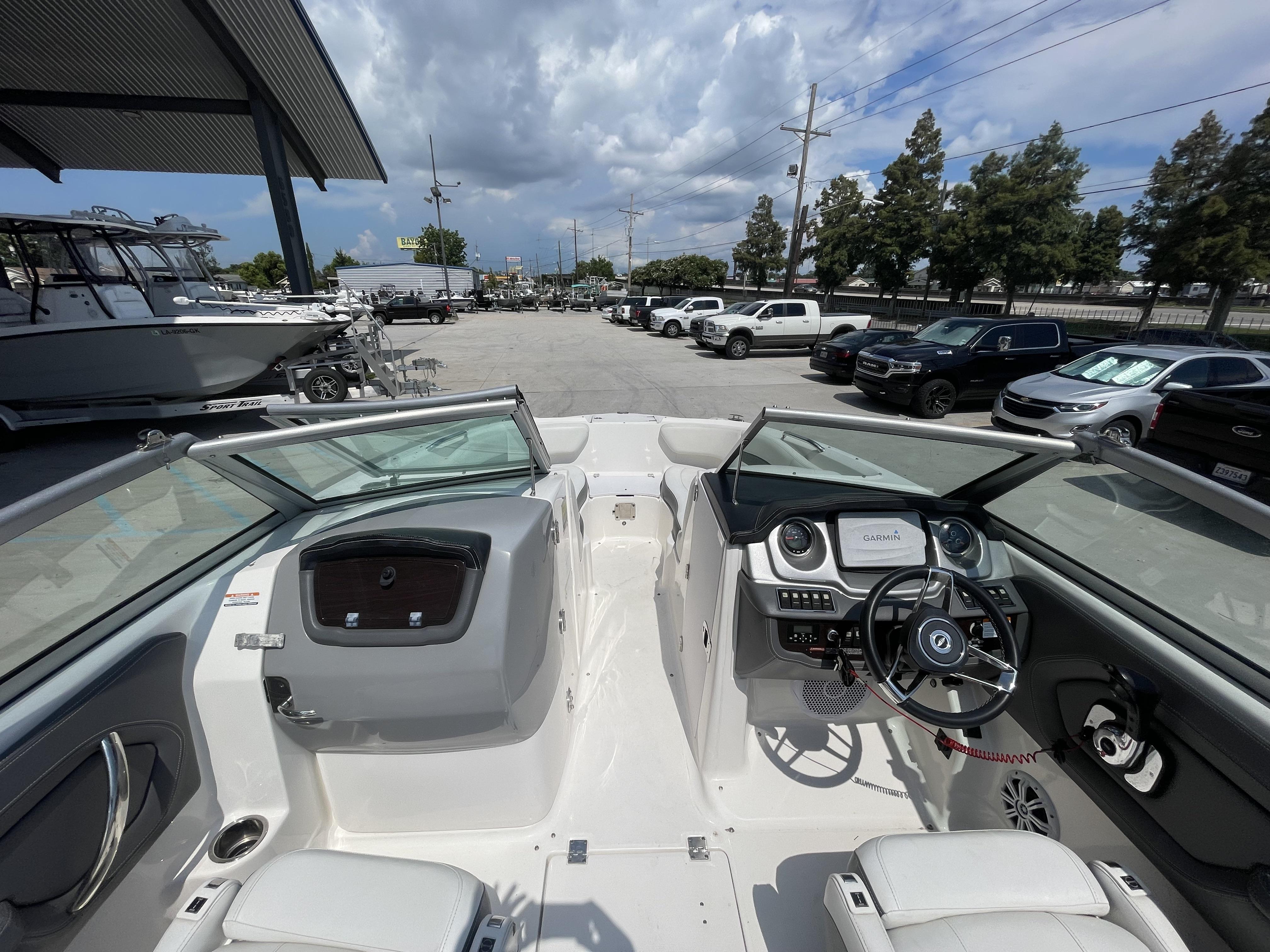 2014 Chaparral Sunesta 224 boat interior with steering wheel and dashboard, parked outdoors.