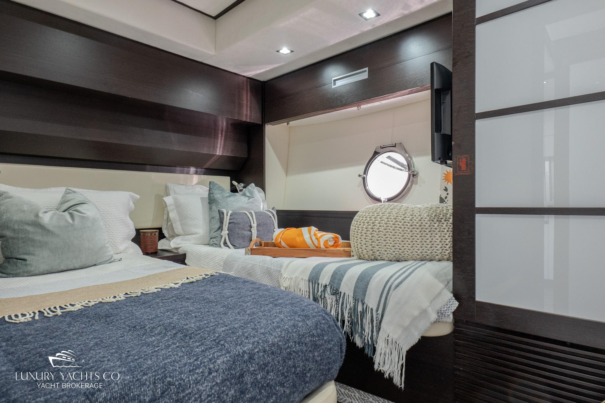 Luxurious 2010 Azimut 62S yacht bedroom with modern decor and cozy bedding.