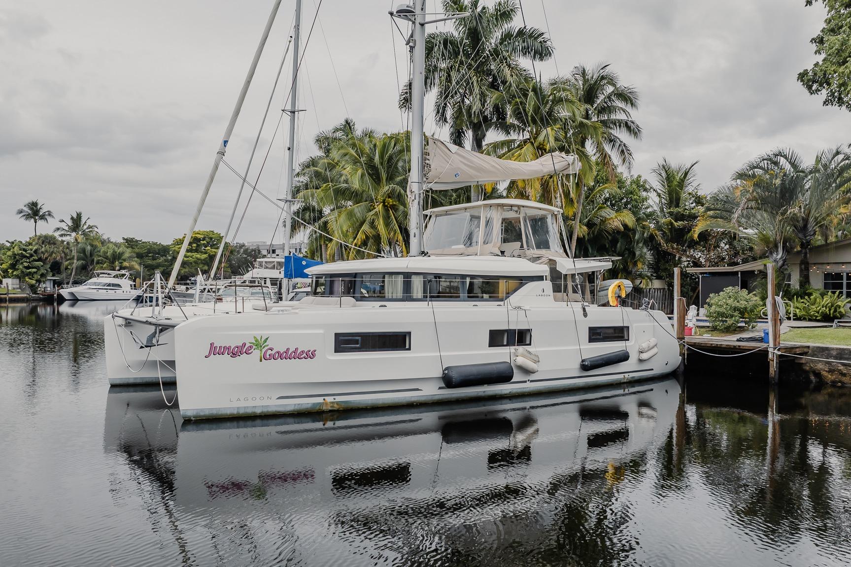 2022 Lagoon 46 catamaran "Jungle Goddess" docked by tropical palm trees.