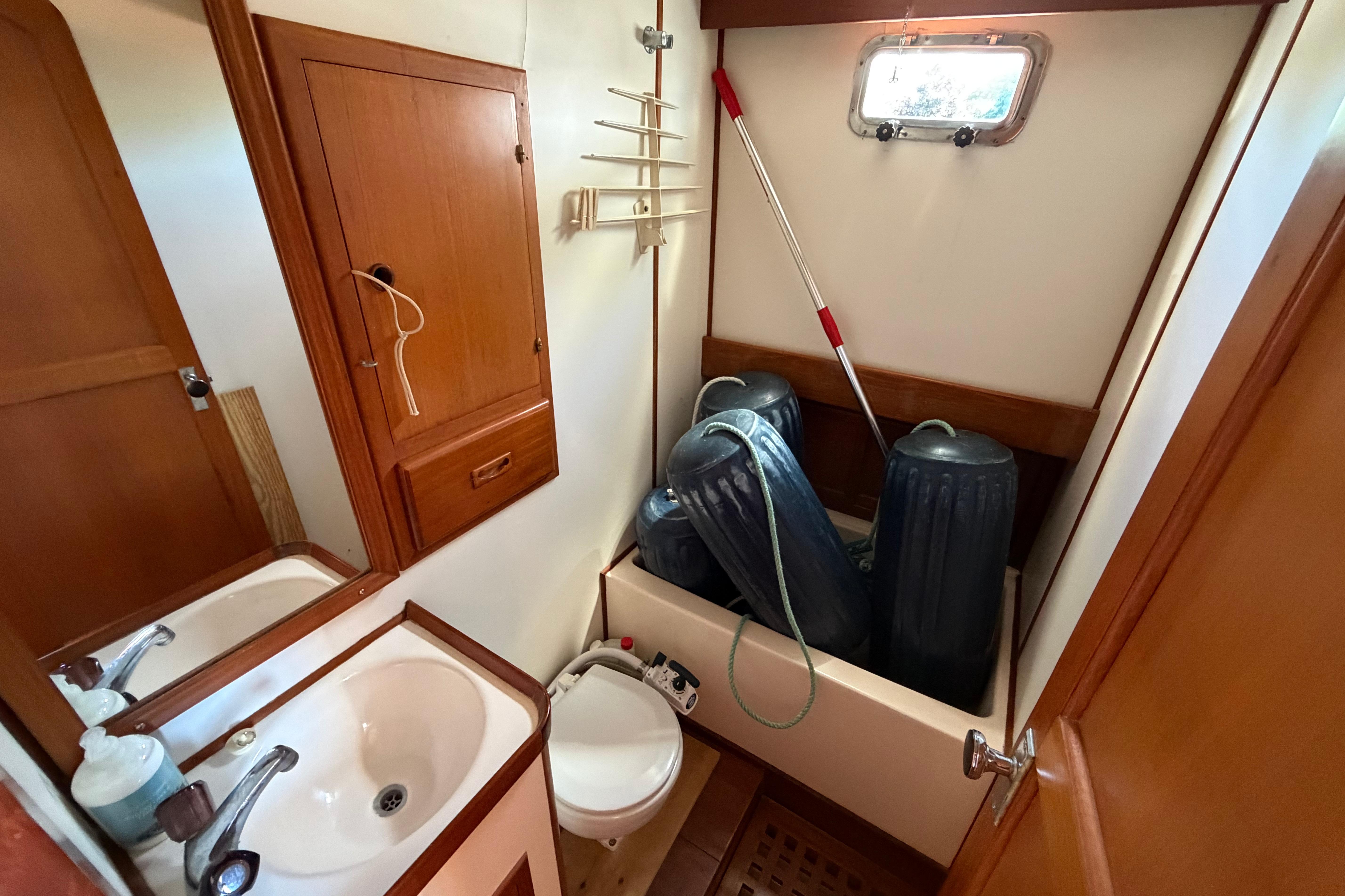 Bathroom interior of 1987 Marine Trader 36 yacht with sink and storage.