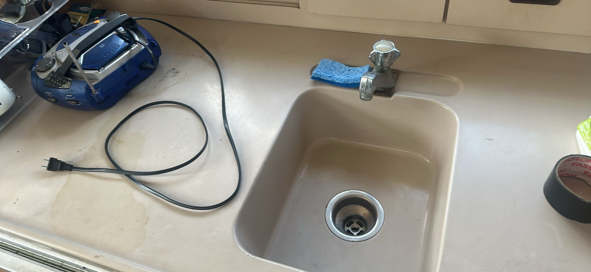 Kitchen sink on a 1974 Bertram 28 boat with radio.