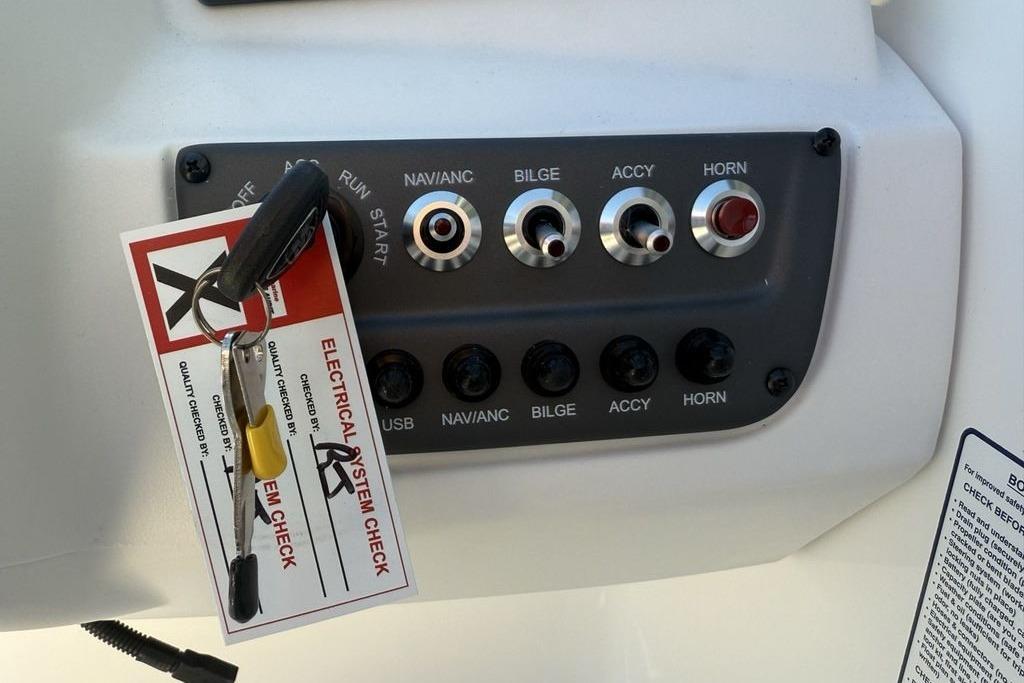 Control panel of 2026 Tahoe T16 boat with electrical system check tag.