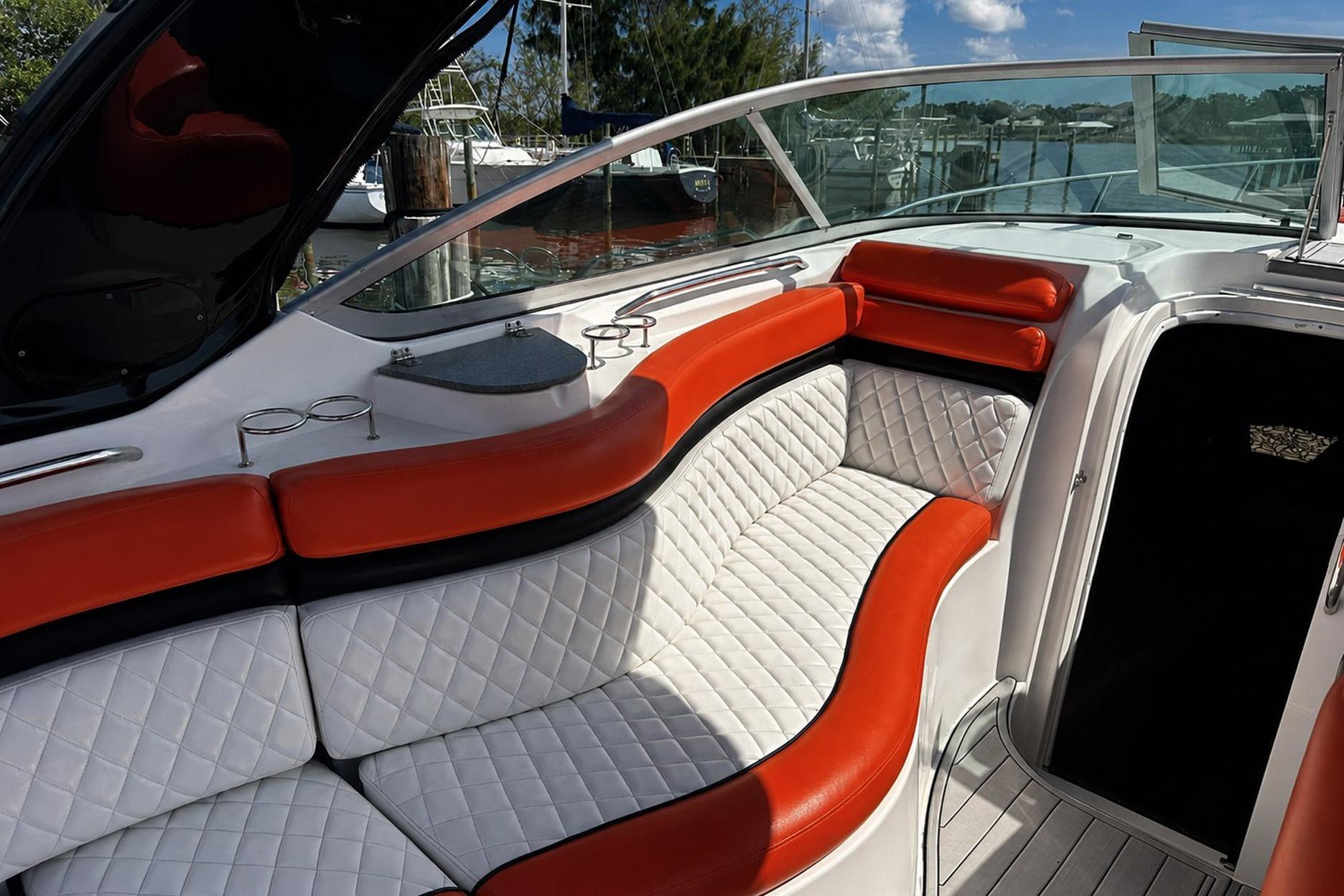 2012 Rinker 310 Express Cruiser LE interior with red and white seating, docked by water.